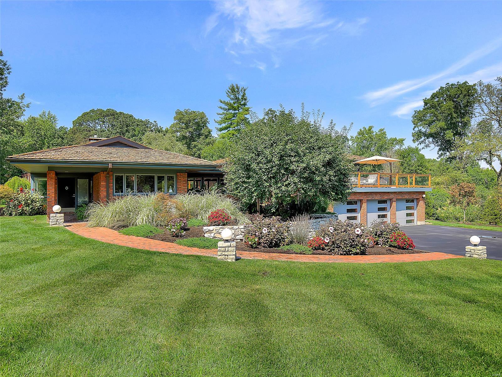 A true show stopper, this impeccably maintained and beautifully renovated contemporary home on a private Ladue lane lends itself to both modern and traditional tastes. A stunning open floorplan welcomes you and immediately you are taken away by the impressive windows, incredible finishes and treasured design. The remarkable kitchen with adjacent mudroom with cubbies is open to the striking dining room and entry gallery. Off the gallery is the expansive living room and den. Up a few stairs you'll find a bonus area which could be an office or homework space with sliding doors that lead to a 700+ square ft deck. On this level you will also find 4 bedrooms and 4 baths; the master featuring his and hers full baths. All rooms equipped with electric blinds, impressive baths and walk-in closets. The ground floor offers a family room, exercise room, an en suite bedroom, and an addl bedroom. A large laundry, 3 car garage and extraordinary landscaping round out this spectacular property. Additional Rooms: Mud Room