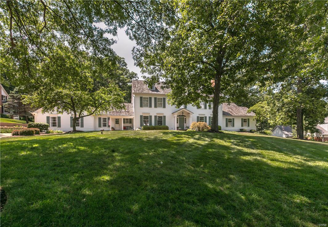 This classic, Grotpeter-built, Williamsburg colonial 1.5 story home is located in the heart of Town & Country on a beautiful 1 acre wooded lot backing to Longview Farm Park in prestigious Wheatfield Road Subdivision. As you enter this 5 bedroom, 5/2 bathroom home you are met with a grand open staircase that leads to 4 second floor bedrooms with generous room dimensions and wood flooring. The main floor features the master suite with fireplace and library, formal living & dining rooms, family room, kitchen, breakfast room, mudroom and laundry. The vaulted sun room overlooks the beautifully landscaped and lighted patio, terrace and backyard. The home also features 9 ft. ceilings, a second back staircase and 5 fireplaces. Extensive custom mill-work throughout and wide plank white oak floors enhance the charm and beauty of this home. Walkout lower level includes second family room with fireplace, game room with wet bar, full bath, workout area. Additional Rooms: Mud Room, Sun Room