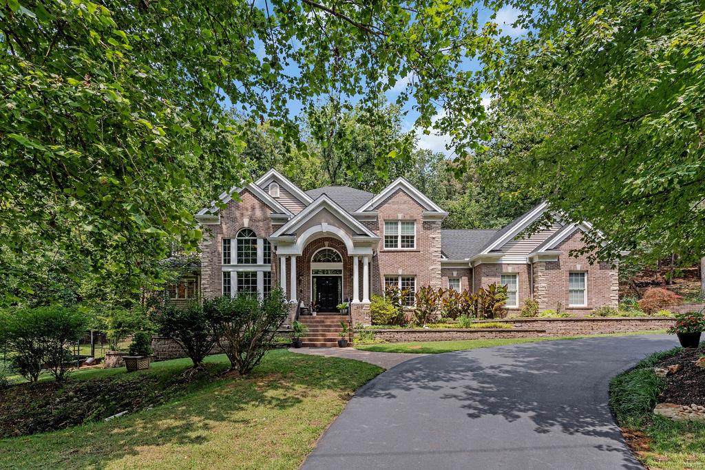 Welcome to 819 New Ballwin Road, a stunning 4-bedroom, 4.5-bath home that beautifully blends luxury & nature. Upon entering, you are greeted by a grand two-story foyer and an impressive curved staircase. The library boasts custom cabinetry and soaring ceilings, creating a majestic space. The large eat-in kitchen, featuring a breakfast bar, designer appliances, and a walk-in pantry, seamlessly opens to the great room, where large windows offer breathtaking views of your private hillside. The main floor primary suite is a peaceful retreat, complete with a luxurious bathroom & walk-in closet. Upstairs, you'll find three additional spacious bedrooms, along with a bonus room ideal for an office or play area. The walk-out lower level is an entertainer’s dream, with a media area, bar, full bath, large storage space, and still room for an exercise area and games. This home is equipped for both entertaining and relaxation. 3-car garage, main floor laundry. Rockwood Schools. Don't wait!