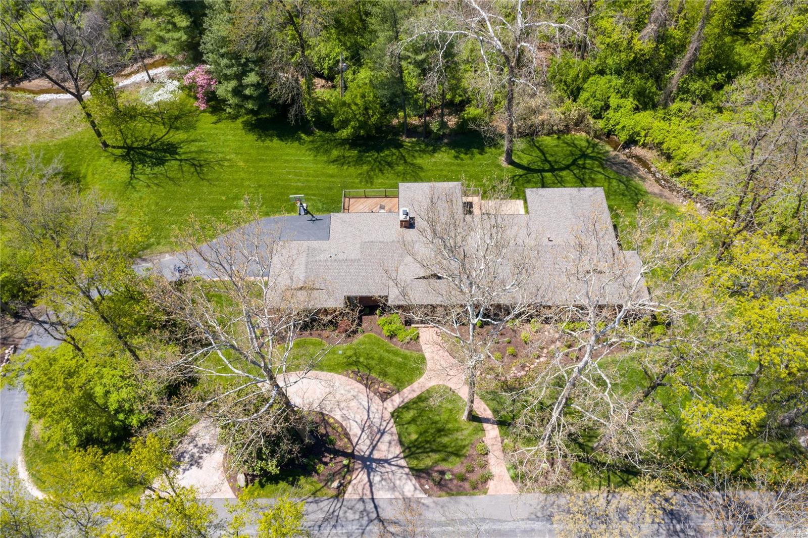This Ralph Fournier-designed contemporary is quietly situated on a private professionally landscaped 1.8-acre lot.  This home has been meticulously taken to the next level to incorporate the busy lifestyle of today’s stylish buyer.  Find floor to ceiling windows and glass doors providing access to Ipe decks wrapped in glass overlooking the backyard.  The updated custom kitchen with wet bar flows seamlessly into the family rm with 3 walls of windows.  The formal dining rm and living rm share a see through custom marble fireplace.  The master suite is a luxury retreat with spa bath, heated flr and walk in custom closet.  Find 2 bedrms, full bath with steam shower and heated flr, laundry and guest powder on the main level.  The walk out lower level features a large rec rm, exercise rm, additional laundry rm, hall bath and a well appointed bedrm suite perfect for guests.  Custom shutters, whole house generator, Creston automation, Tesla charger and so much more.  Perfection.