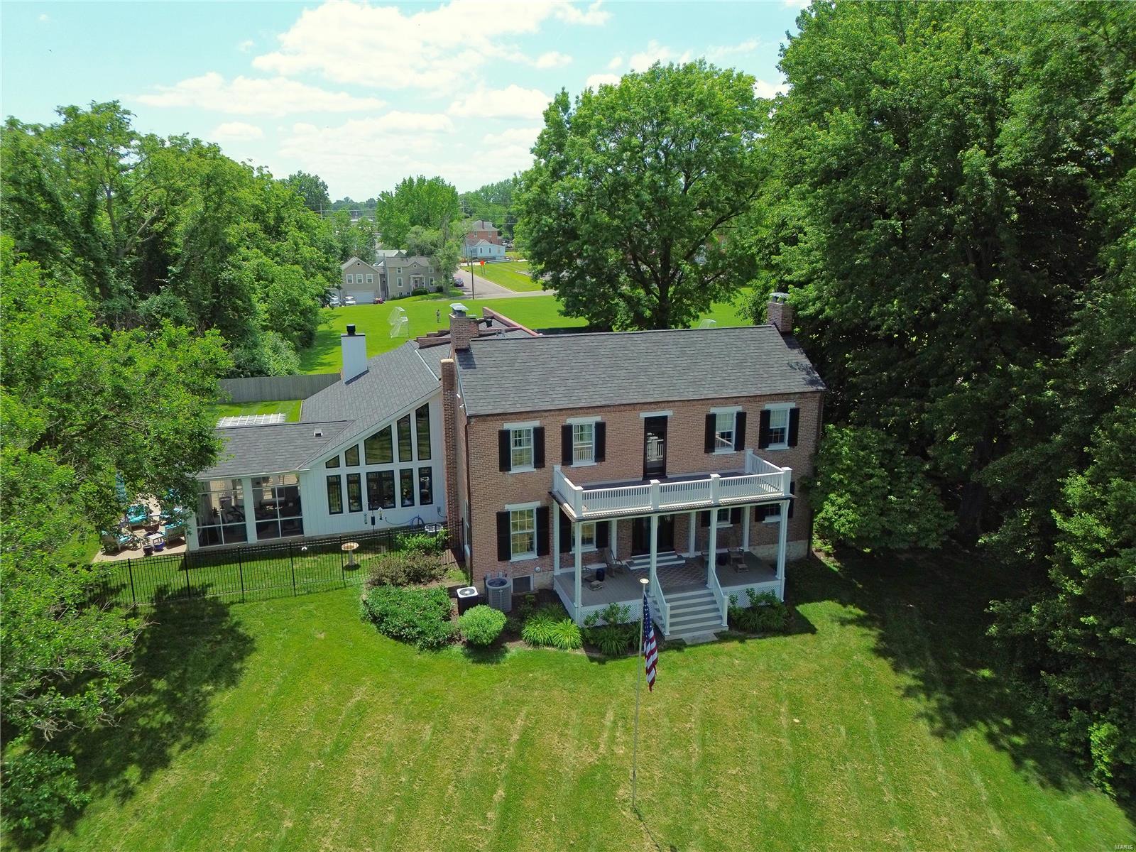 Welcome to the Estate of Lucinda Owens, the founder of Washington MO! Featuring a Missouri River View, this stunning property was built in 1838 on 1.3 acres. Boasting a perfect blend of classic architecture & modern updates, the Grand Entry Foyer leads you to either the Library w/ a fireplace & built-in bookshelves to the left or straight ahead to the dining room, which is perfect for entertaining guests w/ seating for up to 12. The chef's dream kitchen is a true masterpiece, w/ granite countertops, Wolf/Subzero/Bosch, abundant cabinets, extras, & huge island with seating connecting to the hearth area & adjacent breakfast room. The parlor is perfect for relaxing after a long day or holiday gatherings. Upstairs offers a massive primary bedroom suite including a Luxury bathroom. Plus 2 additional bedrooms & charming hall bath. Offering 2 Front Porches, Large Patio, & Sunroom. 3-Car Garage. High Ceilings & Large glass windows offer breathtaking views of the beautifully landscaped grounds. Additional Rooms: Wine Cellar
