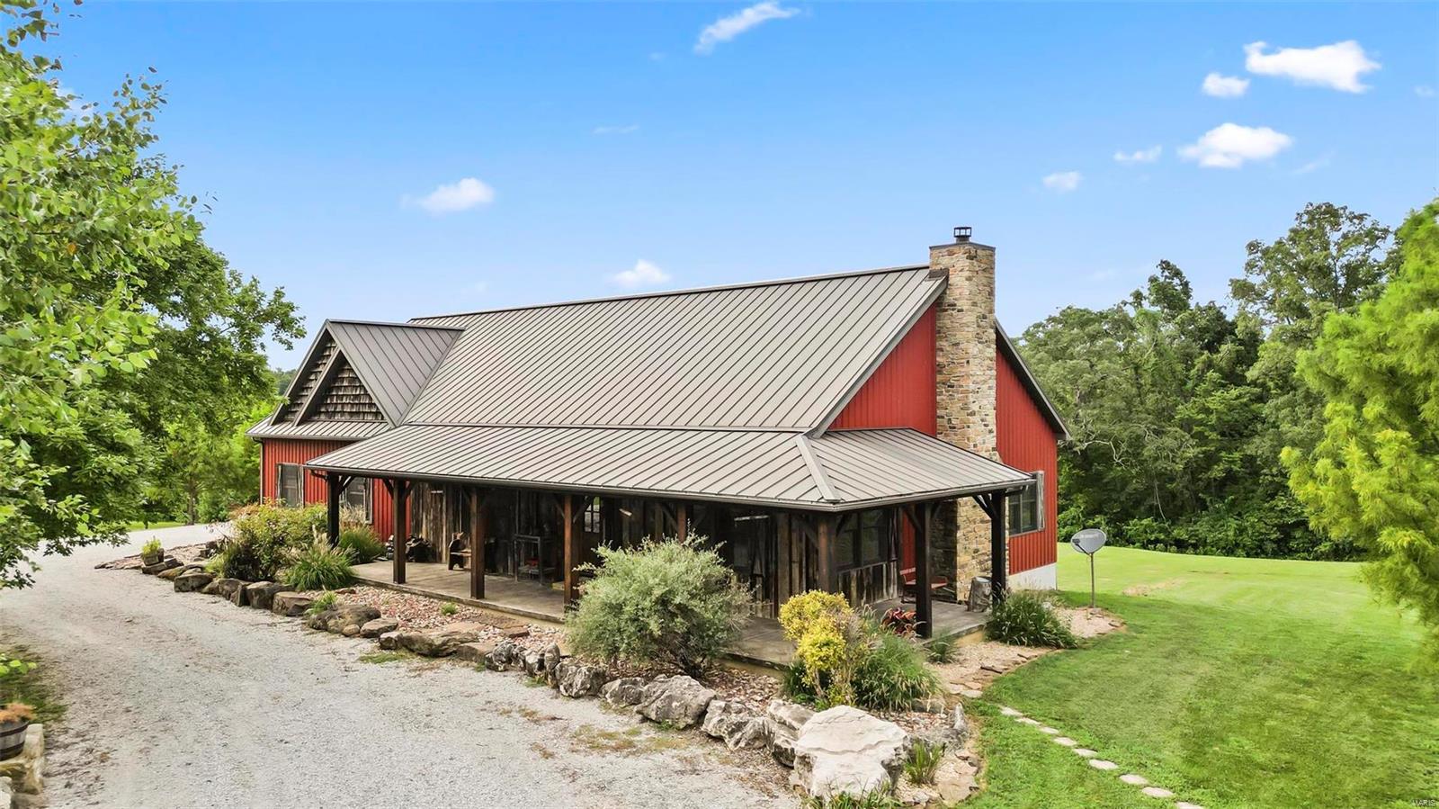 Nestled within 6+ acres, this 1.5-story custom-built home is a historical paridise. The exterior showcases a combination of tin & treated barn wood, exuding a vintage appeal. The rustic loft beautifully reflects the home's rich history, offering a picturesque view of the cozy living room, the true heart of this charming residence, featuring American reclaimed hardwoods legacy flooring with majestic grain character and detail. Vintage barn wood stair steps with custom-treated tree bark stairway railings that add a touch of nature-inspired artistry. The living room is the heart of the home, with vintagecraft beams throughout & a cozy wood-burning fireplace that invites you to relax. The kitchen is a chef's delight, boasting ample cabinet space, a center island, and a stone backsplash that adds a rustic elegance. A walk in gun vault is located in the basement with steps going up to the 2-car oversized attached garage. 96x80x48 insulated shed with concrete flooring, electric & water.