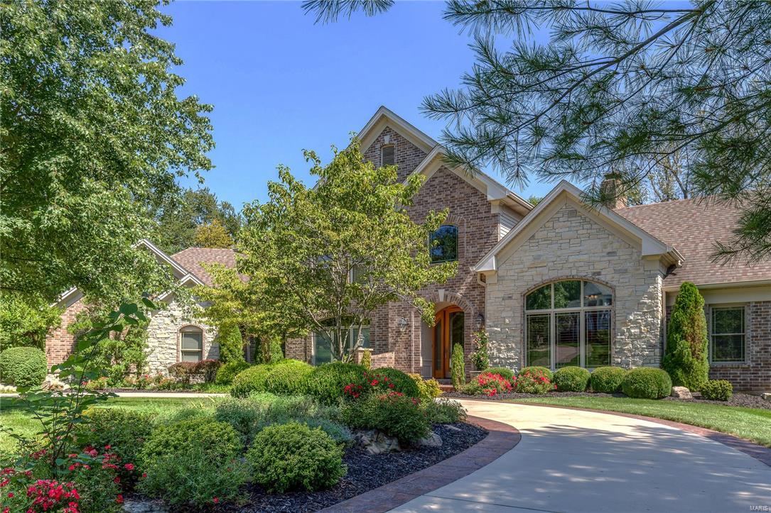 Stunning architectural details & meticulous maintenance set this 1.5 story home apart. Walls of windows & gleaming wood floors grace the generous rooms that flow effortlessly & envelope you with extensive moldings, commanding fireplaces & interesting ceilings. Formal spaces include a large living room with wet bar & fireplace, an office with stately paneling & a dining room that is suited for grand parties. Casual gatherings gravitate to the kitchen with custom cabinets, granite and SS appliances, all of which opens to a hearth room with a stone fireplace. Views of the wooded lot are seen from the master suite with his/hers closets & luxurious bath. The 2nd floor has two ensuite bedrooms. High end finishes continue through the lower level with huge open spaces that connect via a 2nd kitchen/bar. Find serenity by the infinity pool & soak up the nature that abounds on this beautiful lot! 3 car garage,irrigation and a BRAND NEW ROOF! Convenient to Queeny Park, shopping & highways. COOL: 14 SEER+