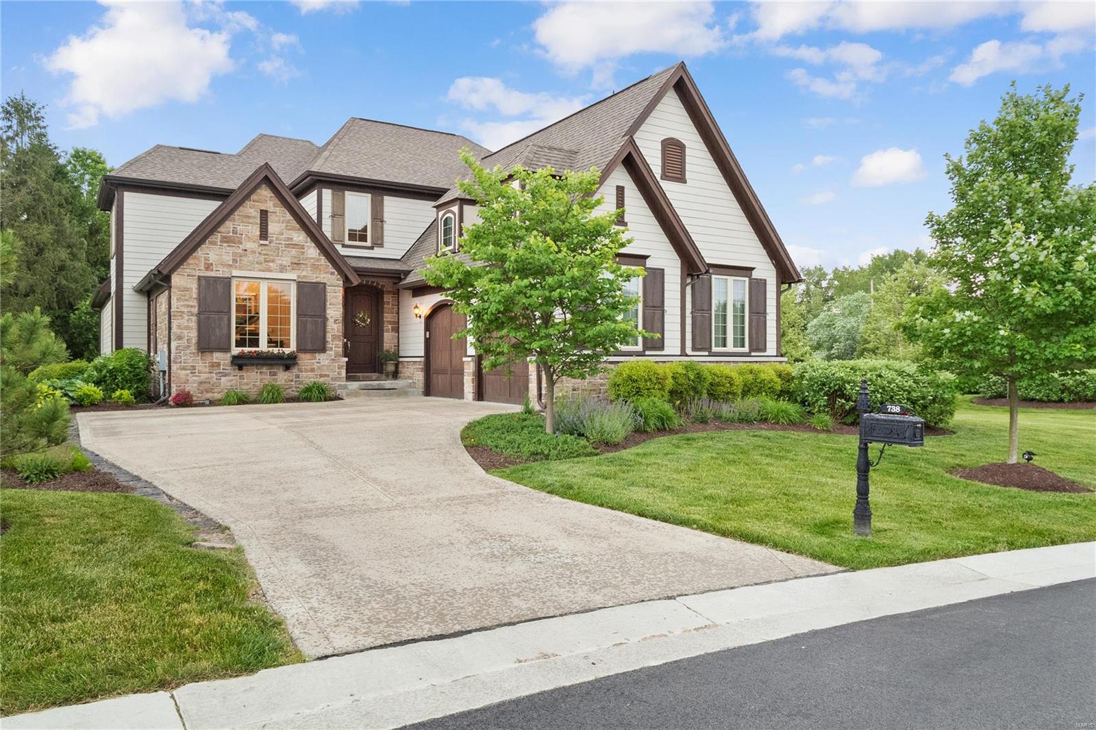 Stunning display home with Designer interior, featuring high-end finishes and situated on a superior lot which backs to secluded unbuildable common ground! OVER 4,600 SF of Low maintenance living (all inclusive landscaping maintenance and snow removal for a care free lifestyle) situated within miles of shopping, dining & entertainment - Ladue school district. This distinctive Naples inspired plan includes 2-story Foyer & Great Room, gourmet Kitchen w/stacked cabinetry/quartz countertops, Dining Room, Butlers Pantry, expanded 1st floor Owners Suite w/ vertical spa, walk-in closets, hardwoods throughout 1st floor. Two BRs separated by Jack-n-Jill bath on 2nd floor plus flexible bonus room. Beautifully finished lower level including  Family Room, Game area, Wet Bar, Bedroom, 3-piece Bathroom & Exercise room...This home is a must see. Enjoy a rare combination of luxury, convenience, & lifestyle at Woods of Ladue. Make your appointment today!---PRICE ADJUSTMENT