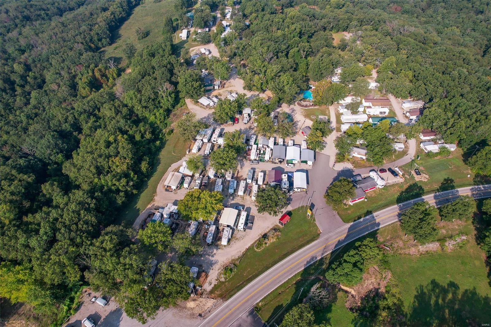 Want the pleasure of loving your own business while enjoying life at the same time?  You can own this well established Campground near Bennett Spring State Park in Lebanon, MO.  You can feel like you are on a permanent vacation & have fun making money! This amazing property sits on a HUGE 63 acre lot w/ 280 sq ft of State HWY frontage! Land on 3 sides of this property belongs to the State Park, wildlife galore, caves, bluffs, ozark hills! Turn key, income bearing RV campground with 8 overnight cabins! The large 170+ site campground is fully rented with a waiting list of happy campers! Year around income & No Vacancy! Campground features include: Infinity Edge saltwater pool & hot tub with 3 waterfalls, basketball court, playground, commercial laundry room & bathrooms with showers. Property has a 2021 3/2 DW that will stay for manger suite, Pole Barn for storage & a couple of outbuildings. Not located in a flood zone. High dollar county approved Septic systems!  Managers will train! Location: Rural