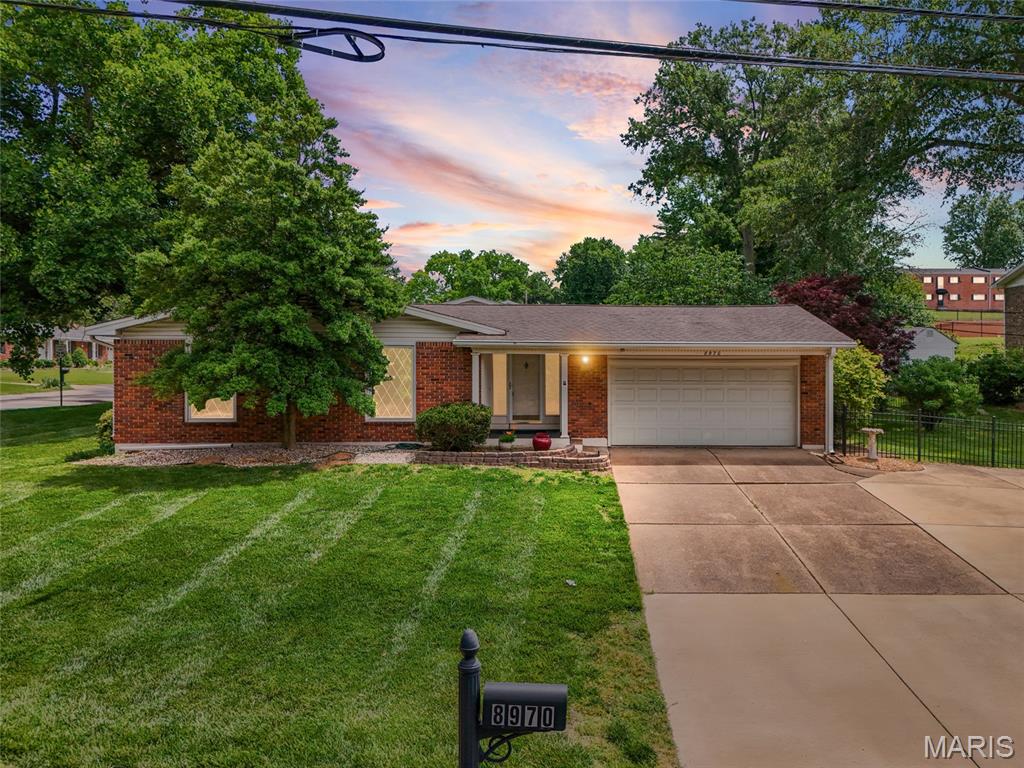 MOTIVATED SELLER! 
Welcome to this spacious and well-maintained ranch home perfectly located within walking distance of Grant's Farm. Offering 3 bedrooms and 2 full bathrooms on the main level, this home features exposed hardwood flooring, fresh interior paint, and updated light fixtures throughout portions of the home. The main level includes a large living room, separate dining area that could also serve as a formal sitting area, and a screened-in porch/sunroom overlooking the fenced backyard and side yard. The finished lower level provides additional living space with a spacious family room, large laundry room, full bathroom, and two additional rooms that could serve as sleeping areas, offices, hobby rooms, or flex spaces. An attached two-car garage offers convenience and additional storage. This home offers additional peace of mind with a all home generator! Conveniently located near shopping, dining, parks, and major commuter routes, this home combines generous living space, functional updates, and an excellent location. Don't miss this opportunity to make it your own.