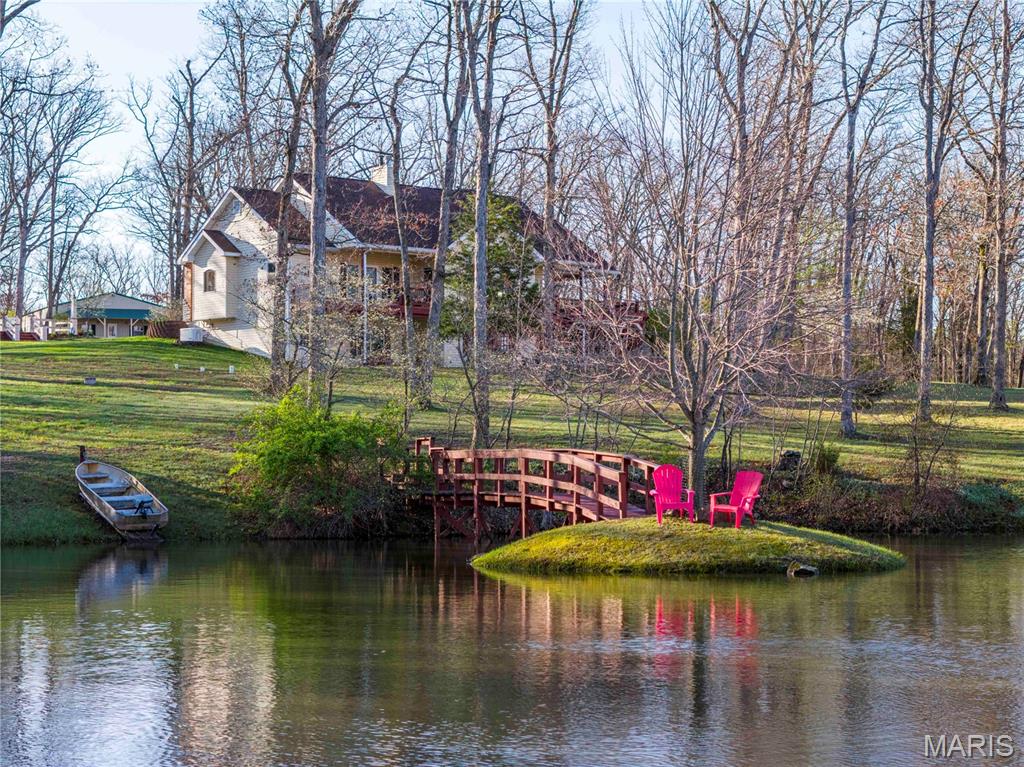 Rose n’ Oak Farm is an incredible 57-acre estate centered around a pristine 3.6-acre private lake and a custom-built home. It’s clear this place was built with intention, patience, and a long-term vision. The 3-bedroom, 2.5-bath home offers just over 3,700 total living sq ft, with 2,167 sq ft on the main level. It is all laid out in a clean, open concept full of natural light. The kitchen has beautiful wood cabinets, solid-surface counters, and stainless-steel appliances, all anchored around a perfectly sized island. For dining, head to the dining room, surrounded by windows, or step right out the French doors onto the covered deck designed for enjoying the view. After dinner, head to the family room. It’s hard to decide what is more impressive: the vaulted ceilings, the stone fireplace, or the massive picture window that captures a full, unobstructed view of the lake. The primary suite is set just off the family room and has its own private covered deck overlooking the water, along with a well-finished private bath featuring a garden tub, separate his-and-her vanities, a large separate shower, and a walk-in closet. All this, with a perfectly located office, main floor laundry, and powder room, rounds out the main floor. The lower walk-out continues to impress with two more bedrooms and a full bath. The large great room really pulls you in, complete with a wood stove, coffered ceilings, built-in bookshelves, and French doors that walk out to the patio. Head into the rec room, built for entertaining, with plenty of space for guests, game nights, or extended stays. Notice the details of the arched doorway and custom recessed lighting over the pool table- craftsmanship at every turn. The home is supported by a brand-new geothermal HVAC system and a 17kW backup generator to keep everything running when it matters. Head outside where precision and quality continue. The patio, with two pergolas, a water feature, and a fire pit, creates a space that’s just as usable as the interior and perfect for a quiet evening or to become the go-to host. The lake is the centerpiece and has been meticulously developed and maintained. Fully stocked, aerated, and exceptionally clean, it’s surrounded by a trail system. You’ll find multiple docks and fishing points, thoughtfully placed benches, a pump house and garden, a fishing shack, and a small island. There is a clubhouse on the north shore, perfect for the kids or for turning it into an art studio or a rustic guest cabin. The outbuildings are equally impressive and built with purpose. The 35x50 shop features a full concrete floor, double sliding doors, and a wood stove, making it a year-round workspace. Also, there is an additional 700 sq ft of finished living quarters with top-tier finishes throughout, including a full kitchen, bathroom, and bedroom, ideal for guests or extended family. Your equipment will stay out of the rain with the 30’x40’ equipment shed with a lean-to. There are two additional structures set up for sawmill operation and lumber storage. These can be used to store more equipment or to purchase a sawmill and mill your own lumber. A large portion of the equipment, including the sawmill, is available for purchase, offering a turnkey opportunity for someone looking to utilize the land in a meaningful way. The land is a strong mix of oak and hickory timber, along with open ground, offering beauty, privacy, and usability. A new owner could easily set it up for horses or manage it for hunting. A thorough trail system will take you to every corner of the property. This is not a pieced-together property. It’s a complete, well-executed estate, with every improvement made with care and intention. Private, functional, with craftsmanship in every detail, Rose n’ Oak Farm was built to be enjoyed for generations. Properties like these take a lifetime to build and rarely come to market.