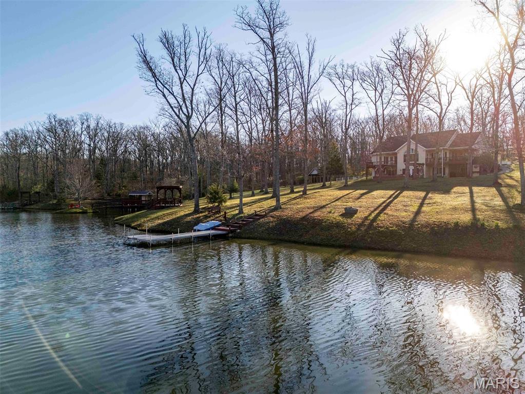 This is the kind of place people try to build for a lifetime but rarely pull off. Rose n’ Oak farm is an incredible 57± acre estate centered around a pristine 3.6-acre private lake and a custom-built home. From the moment you come down the winding private drive, it’s clear this place was built with intention, patience, and a long-term vision.

The 3-bedroom, 2.5-bath homes offer just over 3,700 total living sq ft with 2167 sq ft on the main. It is all laid out in a clean, open concept full of natural light. The kitchen has beautiful wood cabinets, solid-surface counters, and stainless steel appliances, all anchored around a perfectly sized island. For dining, head to the dining room, surrounded by windows, or step right out the French doors onto the covered deck designed for enjoying the view. After dinner, head to the family room. It’s hard to decide what is more impressive: the vaulted ceilings, the stone fireplace, or the massive picture window that captures a full, unobstructed view of the lake. The primary suite is set just off the family room and has its own private covered deck overlooking the water, along with a well-finished private bath featuring a garden tub, separate his-and-her vanities, a large separate shower, and a walk-in closet. All this with a perfectly located office, main floor laundry, and powder room round out the main floor.

The lower walk-out continues to impress with two more bedrooms and a full bath. The large great room really pulls you in, complete with a wood stove, coffered ceilings, built-in bookshelves, and French doors that walk out to the patio. Head into the rec room, built for entertaining, with plenty of space for guests, game nights, or extended stays. Notice the details of the arched doorway and custom recessed lighting over the pool table, craftsmanship at every turn. The home is supported by a brand-new geothermal HVAC system, along with a 17kW backup generator to keep everything running when it matters. Head outside where precision and quality continue. The patio, with two pergolas, a water feature, and a fire pit, creates a space that’s just as usable as the interior and perfect for a quiet evening or to become the go-to host.

The lake is the centerpiece and has been meticulously developed and maintained. Fully stocked, aerated and exceptionally clean, it’s surrounded by a trail system. You’ll find multiple docks and fishing points, thoughtfully placed benches, a pump house and garden, a fishing shack, and a small island. There is a clubhouse on the north shore, perfect for the kids, or turn it into an art studio or rustic guest cabin.

The outbuildings are equally impressive and built with purpose. The 35x50 shop features a full concrete floor, double sliding doors, and a wood stove, making it a year-round workspace. Also, there is an additional 700 sq ft of finished living quarters with top tier finishes throughout, including a full kitchen, bathroom, and bedroom, ideal for guests or extended family. Your equipment will stay out of the rain with the 30’x40’ equipment shed with a lean-to. There are two additional structures set up for sawmill operation and lumber storage. These can be used to store more equipment or purchase the sawmill as well, and mill your own lumber. A large portion of the equipment, including the sawmill, is available for purchase, offering a turnkey opportunity for someone looking to utilize the land in a meaningful way.

The land is a strong mix of oak and hickory timber, along with open ground, offering beauty, privacy, and usability. A new owner could easily set it up for horses or manage it for hunting. A thorough trail system will take you to every corner of the property.

This is not a pieced-together property. It’s a complete, well-executed estate where every improvement was done with care and intention. Private, functional, craftsmanship in every detail, Oaks & Roses was built to be enjoyed for generations. Properties like these take a lifetime