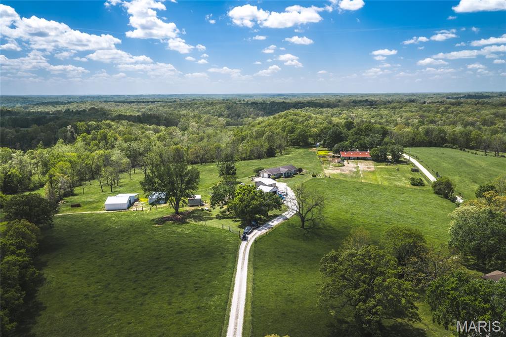Discover the perfect blend of privacy, functionality, and natural beauty on this stunning 42-acre property.  Featuring lush, green pastureland complemented by just the right amount of wooded acreage, this land is ideal for livestock, recreation, or simply enjoying the outdoors. Deer and turkey are abundant, offering excellent wildlife viewing or hunting opportunities. The property includes two well-maintained homes. The first is a spacious ranch-style home with a full basement and attached two-car garage. Built with 2x6 walls and excellent insulation, it offers impressive energy efficiency and low utility costs. The second home is a charming farmhouse that has been completely renovated, combining modern updates with classic character. Each home also features its own detached two-car garage, providing ample storage and workspace. Designed with livestock in mind, the pasture is fully equipped for cattle or horses, complete with a barn, corrals, and a cattle working chute. Tucked away at the end of a secluded private road, this property offers peace and privacy while still being conveniently located—just 1.5 miles from town and only 2 miles from Interstate 44.