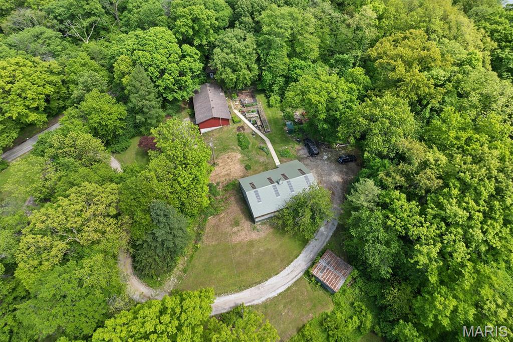 Escape the Ordinary — 3,600 Sq Ft of Thoughtful Luxury on 3.5 Wooded Acres
Trade traffic noise for songbirds on this completely reimagined 4-bed, 3-bath retreat nestled in total seclusion — not a neighbor in sight. Surrounded by mature woods on 3.5 private acres, you'll enjoy the rare gift of complete privacy, yet remain just 20 minutes from Scott AFB. Every inch of this home has been renovated with intention, and it shows.
The chef's kitchen is the heart of the home: handmade spalted maple cabinetry, a 10-foot island with induction stovetop, double-wall convection oven, and a large walk-in pantry. Open concept living and dining flow naturally around a cozy wood-burning stove — perfect for gathering and entertaining year-round.
Generous closets throughout, plus a main bath with a custom sideboard for linens. The primary suite will stop you in your tracks: heated tile floors, live-edge custom cabinetry, a massive walk-in shower with rain head and built-in dog washing station, and a deep Japanese soaking tub in a stunning glass enclosure.
The finished walk-out basement adds flexible living space with storage, utility, and laundry — backed by a whole-house water filtration and softener system and an ultra-efficient, extra-large capacity water heater so hot water is never an afterthought. A generous 400-amp electrical service powers it all, and the home is fully code compliant with county occupancy requirements — giving you confidence from day one.
And then there's the barn. The impressive 1,500 sq ft pole barn is a hobbyist's dream and a hardworker's sanctuary — fully wired for all your shop needs, finished with a solid concrete floor, and EV-ready for electric vehicle charging. Spacious enough to house vehicles, equipment, a full workshop, or whatever your imagination demands.
No HOA — no fees, no rules, no headaches. Just your land, your home, your way.
Home warranty offered for added peace of mind. Motivated sellers — don't wait on this one.
This isn't just a house — it's the life upgrade you've been waiting for. (Acres and taxes reflect totals of both parcels.) AGENT OWNED
