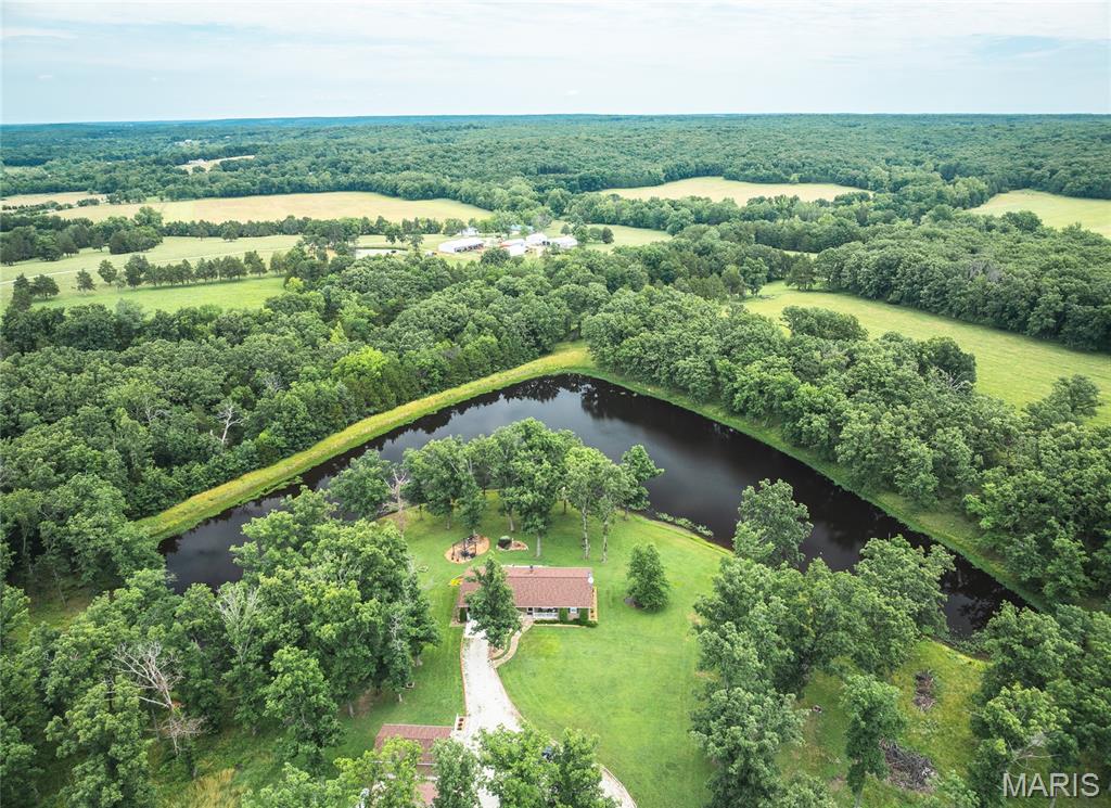 Welcome to your own water-side oasis nestled in the heart of the Ozarks! This stunning property offers breathtaking views and an updated home throughout, set on beautifully manicured, park-like grounds. Start your mornings with coffee on the expansive deck overlooking your private lake, and end your days fishing, floating, or kayaking in nearby crystal-clear rivers—including the Huzzah, Courtois, and Meramec. The roof on all buildings, including the home, is only 1 year old, giving you peace of mind for years to come. The property also features several versatile outbuildings, including a 16x30 shop with a split unit for heating and cooling—perfect for storage, hobbies, or a full-blown man cave/workshop setup. A sprinkler system, fed directly by the lake, keeps the grounds lush and green throughout the season. For outdoor enthusiasts, deer blinds are already in place, and you’re just a short drive from Maramec Springs trout fishery—ideal for fly fishing enthusiasts. Located in an area renowned for trophy whitetail deer, this is a haven for both hunters and anglers alike. Whether you're looking for a peaceful retreat or a basecamp for year-round outdoor adventure, this Missouri land and lake property has it all.