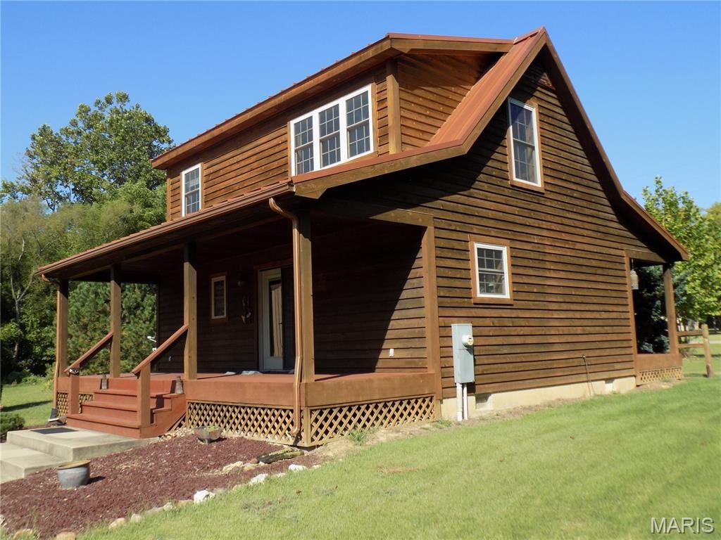 Beautiful custom built western cedar  1.5 story home, with standing seam metal roof, warm hickory wood floors and kitchen cabinets, all wood interior, kitchen with granite counter top, range, refrigerator and laundry room comes with washer and dryer.  There is 1122 sq ft of living area, with a relaxing loft on 2nd floor overlooking living room.  Quality has not been spared with beautiful Anderson windows throughout.  Front and back porches for relaxing in the evenings, central air and heat, and a separate oversized 2 car garage with large storage room, your own "Man Cave", with wood pellet heat, and deck off back door, and a large patio with firepit,  All this on 1.19 acres in town!