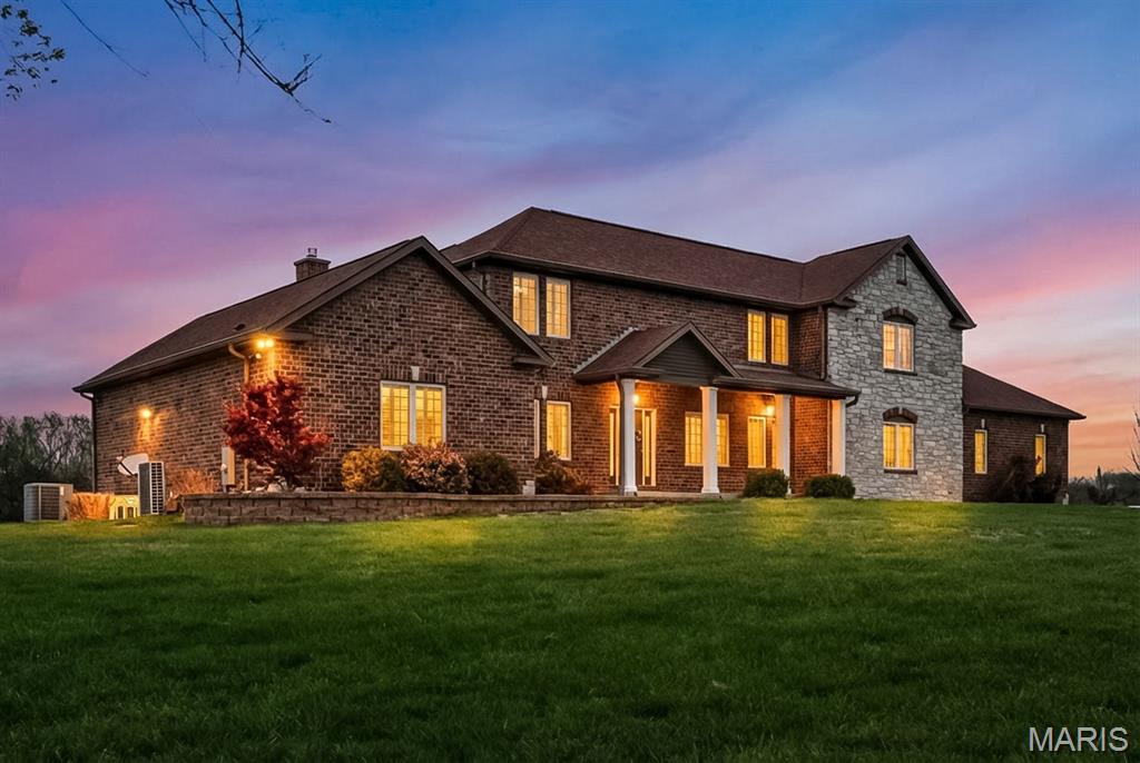 A setting that allows you to step away from it all, without sacrificing everyday convenience. Welcome to this custom-built all-brick and stone estate, privately set on 6.7 acres, a rare offering just minutes from Mercy South. As you arrive, the openness of the land and wooded backdrop create a sense of calm that is felt immediately. Offering a rare combination of usable acreage, privacy, and accessibility, this property delivers the feel of country living while remaining just minutes from major highways. With equestrian potential, this is a lifestyle you can fully experience. As you step throough the front door, the home immediately exudes a high level of quality and custom craftsmanship, with upgraded trim work, crown molding, and substantial 7.25 inch baseboards creating a refined presence throughout the main living spaces. 
The living room opens seamlessly into the kitchen, creating a natural flow, while the full masonry fireplace adds warmth. Just off the main living area, the dining room offers generous space for gatherings and is highlighted by a custom-built dining table and sideboard crafted from wood reclaimed from the original barn that once stood on the property.
The kitchen is a true focal point, centered around a 10-foot island and framed by vaulted ceilings that draw in natural light. Custom cabinetry pairs with granite countertops, along with a 48-inch DCS gas range and stainless hood vent. A 48-inch built-in smart side-by-side refrigerator completes the space. The glass door leads out to the covered patio overlooking the acreage and is the best seat on the property.The walk-in pantry offers custom cabinetry and is complemented by a separate goods and supplies closet. Down the hall, the mudroom features a custom-built hall tree and additional storage, creating a clean drop zone. The gorgeous main level primary suite is set apart to provide privacy. A gas fireplace creates a refined focal point, complemented by custom casing, mantle, shelving, and tile work. Large windows frame the acreage and bring in natural light, while custom plantation shutters provide a timeless finish. The suite also features two custom closet systems. The main floor laundry room includes dual hook-ups. The upper level includes three generously sized bedrooms, including a 17x14 suite with its own private bath, ideal for guests or multi-generational living. The finished lower level is a true extension of the home with 10-foot ceilings. Natural light pours in through the walk-out, highlighting a home gym with specialized flooring and mirrored walls. The recreation space features a full masonry fireplace, with plumbing in place for a future bar. Behind the walls, the home’s construction and mechanical systems are equally impressive, including 8-inch poured concrete foundation walls and full insulation in both the basement and garage. The 31-foot deep by 46-foot wide four-car garage is heated and includes a 1-foot stem wall for full wash-down capability, its own HVAC system, and a direct half-bath that accessible from both the outside or the garage. Additional upgrades include zoned high-efficiency HVAC, two tankless water heaters, and a HALO whole-house water filtration system. There is a 24x40 outbuilding/shed, and a 26x8 greenhouse, creating flexibility for hobbies, equipment, or recreation. The setting offers a rare balance of privacy and convenience, with peaceful acreage just minutes from Tesson Ferry’s shopping, dining, and everyday amenities, along with quick access to major highways. It is a combination that is increasingly difficult to find and even harder to replace. Tucked away, yet close to everything you need. Come check it out for yourself at the open house this Sunday 4/12 from 1-3pm.  Also note this property is just a short distance from several hospitals and medical facilities  so please share this listing if you know anyone in the medical field that requires a short distance to work and might be looking.  Thank you!!