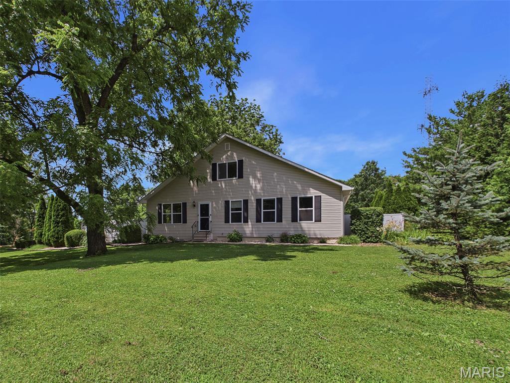 Private 5-Acre Retreat with Room to Roam—Just Minutes from Everything! Enjoy the perfect blend of privacy and convenience with this spacious 4 bedroom, 4 bathroom home situated on 5 beautiful acres. Surrounded by mature trees, lush gardens, and abundant wildlife, this property offers a peaceful country setting without sacrificing easy access to nearby amenities. Step inside to an inviting open floor plan featuring a stunning stone fireplace as the focal point of the living room. The well-appointed kitchen offers stainless steel appliances, abundant cabinetry, and generous counter space, making meal prep and entertaining a breeze. Just off the kitchen, you'll find a large laundry room and pantry combination with a convenient drop zone for everyday organization. The main-floor primary suite provides a private retreat with a spacious walk-in closet and ensuite bathroom. A cozy screened porch just re-screened in 2025 creates the perfect spot to relax while seamlessly connecting the home to the oversized 28' x 32' garage. Upstairs, you'll find two generously sized bedrooms, a full bathroom, and a large storage closet. The finished lower level expands your living space with a family room, wet bar, half bath, and a substantial unfinished area ideal for storage or hobbies. Recent improvements include: Chimney tuck-pointed and waterproofed (Fall 2025), New roof and gutters with gutter guards (December 2025), New water heater (February 2026). As an added bonus, the sellers are leaving behind several valuable outdoor items, including a playset, 54" riding mower with bagger, 48" zero-turn mower, and rototiller. If you've been searching for acreage, privacy, and a move-in-ready home with plenty of space both inside and out, this property is a must-see!