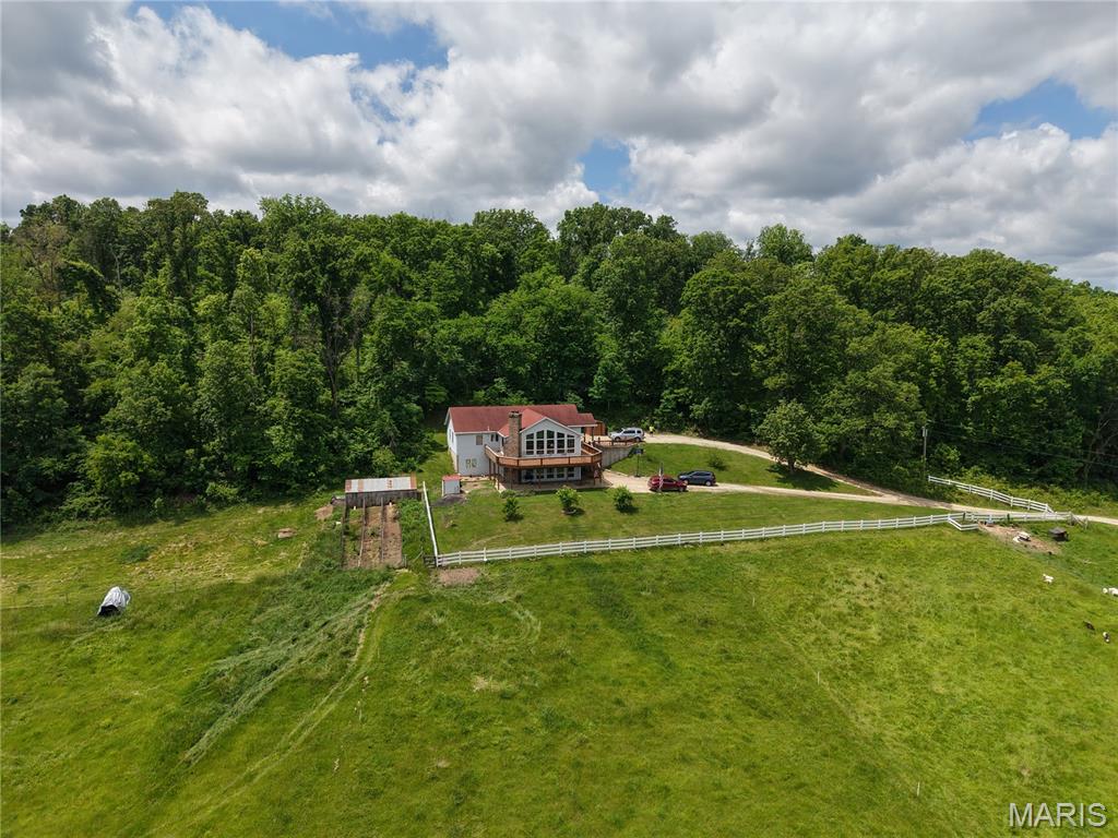 Hunter's and sportsman's dream on 70 +/- acres with approximately 3 acres along the Gasconade River, conveniently located less than 25 miles from I-44 and Rolla. Perched against a backdrop of mature hardwoods, this beautiful home offers the a blend of privacy, open space and views.  The home features a wall of windows that fills the living areas with natural light while showcasing the surrounding countryside. A spacious wraparound deck provides a place to enjoy your morning coffee, evening sunsets, watching the wildlife, the moon the stars and not a single other light when listening to the whippoorwills. The white fencing and long gravel drive gives the welcoming first impression, while the acreage offers endless possibilities for horses, hobby farming, recreation, or simply enjoying peaceful country living. The property features gently rolling hills, pasture ground, and two creeks, along with the acreage bordering River. Whether you love hunting, fishing, horseback riding, kayaking, or exploring with your ATV/UTV, outdoor adventure awaits right outside your door. The spacious 6-bedroom, 3-bath home with nearly 4,000 square feet has two large living areas, each with its own fireplace, updated flooring, oversized windows, and plenty of room for family and guests. A large mechanical room with 9-foot ceilings provides abundant storage space. Whether you're searching for a full-time residence, a family retreat, a hunting lodge, or a weekend getaway, this one-of-a-kind property offers the space, setting, and versatility to accommodate a large group while creating memories that will last a lifetime.