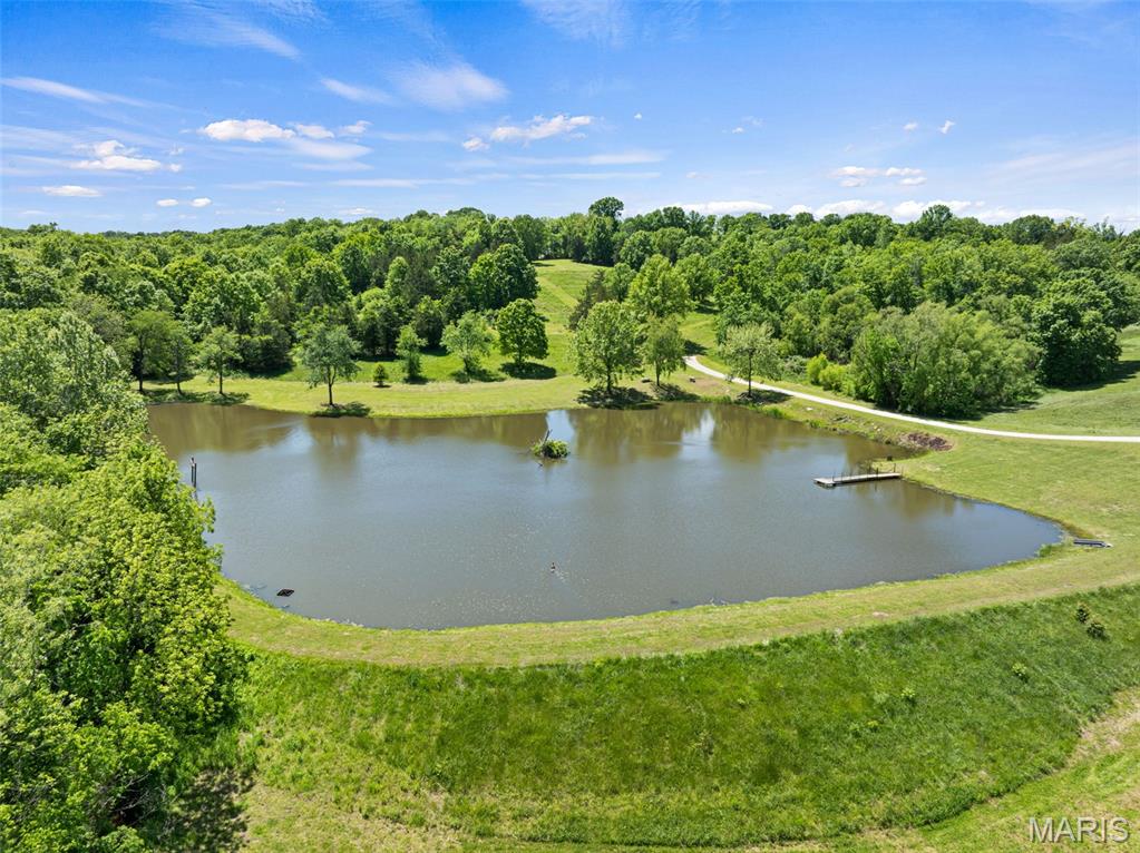 Hidden Ridge Subdivision (Lot 16) presents a rare opportunity to own 13.08 acres of private, scenic countryside just outside Washington. Tucked away off Foggy Court, this exceptional property offers a serene and secluded setting with remarkable potential for a custom dream home. At the heart of the property lies a stunning 2-acre, fully stocked lake, offering excellent fishing for bass, crappie, and bluegill. The lake also draws a wide variety of waterfowl including wood ducks, mallards, geese, and even occasional black bellied whistling ducks, creating a picturesque and ever-changing natural backdrop. Wildlife is abundant throughout the property, with frequent sightings of deer and turkey, making it an ideal retreat for outdoor enthusiasts. Adding to its unique character, Native American artifacts have been discovered on the land, and the wooded areas are known for producing sought after morel mushrooms each spring. Enhancing both lifestyle and setting, the property borders the back nine of Wolf Hollow Golf Course, offering beautiful golf course views and the rare convenience of direct access for an impromptu round just moments from your home. Lot 16 offers excellent accessibility with two established access points, including an easement to the south and a privately owned road to the north, providing flexibility in the design and placement of your future residence. Multiple build sites are positioned throughout the property, highlighted by a premier hilltop setting that serves as the crown jewel. From this elevated vantage point, you will enjoy sweeping panoramic views of the lake and the rolling hills of east central Missouri, along with an ideal setting to take in both sunrise and sunset. Properties of this size and caliber within a subdivision setting are increasingly rare, especially those that offer a blend of privacy, water features, scenic beauty, and abundant wildlife. Lot 16 represents a truly exceptional Missouri countryside estate opportunity, ready to be shaped into a one-of-a-kind retreat.