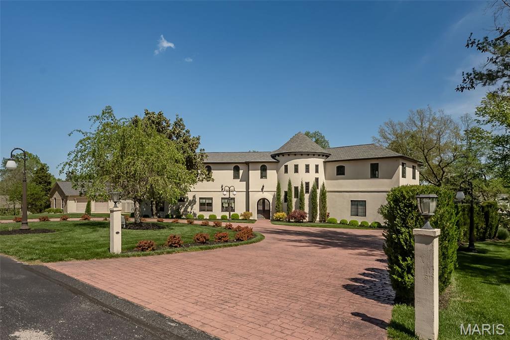 Experience West Coast-inspired luxury in this completely reimagined 6-bed, 5-bath French country-style estate, offering 4,400+ sq ft of living space on more than half an acre in the Parkway South district. Step into a grand entry foyer with soaring ceiling, columns (hand-carved mahogany shipped in from Indonesia), and arched walkways, flowing into an elegant floor plan with designer finishes throughout. Custom-designed Chef’s kitchen dazzles with extensive custom cabinetry, granite counters, an expanded center island, and SS appliances with views overlooking your heated saltwater pool. The outdoor pavilion, with a built-in grill and a pizza oven, is complete with a full brick fireplace for those chilly evenings; this home invites entertaining with ease and offers plenty of privacy. From the foyer, the spiral staircase leads you to an expansive bonus room perfect for additional living space. The primary master suite offers privacy tuck away from the hustle and bustle of life and is completed with his and her walk in closets, spacious primary bath complete with double vanity, walk in shower and more, away from the primary suite, you will find a second kitchen which is part of a complete apartment/in-laws’ quarters above the 3-car garage, complete with its own private entrance. With walnut floors, rec room, office, and private bedrooms—ideal for multigenerational living or extended stays—two separate laundry areas were thoughtfully placed to offer many options while taking advantage of this prime location, minutes from shopping, schools, and major highways. This is a sought-after location. Added to the home is a central vacuum system and an in-ground sprinkler system for easier maintenance of the grounds and landscaping. This home is truly a blend of comfort and West Coast-style sophistication. What a transformation this residence experienced as it was completely rebuilt in 2019. STL county occupancy inspection PASSED!