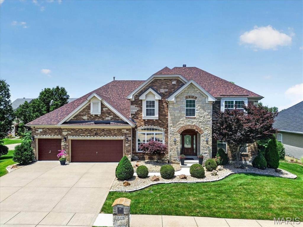 Welcome to 119 Elderberry Lane, a stunning 4-bedroom, 3.5-bathroom Barclay model home nestled on a prime cul-de-sac lot in the sought-after Enclaves at Cherry Hills community in Wildwood, Missouri. Offering over 3,500 square feet of beautifully designed living space, this 1.5-story home strikes the perfect balance between everyday comfort and elevated entertaining. Gleaming newer hardwood floors welcome you at the entry and carry you through the main level, immediately setting the tone for the warmth and craftsmanship found throughout the home. The soaring two-story great room is the true heart of the home, anchored by a dramatic stone gas fireplace and framed by a wall of windows that bathe the space in natural light throughout the day. To the left, the gourmet kitchen is designed to impress, featuring granite counters, custom wood cabinetry, and a full suite of stainless steel KitchenAid appliances including a gas cooktop, double wall oven, built-in microwave, dishwasher, and freestanding refrigerator. A coffee bar, wine rack, dedicated planning desk, pantry, and a large center island with breakfast bar round out this exceptional space. The separate dining room sits adjacent to the kitchen and offers an elegant setting for more formal gatherings, with large windows keeping the space light and airy. The main floor primary suite is a true retreat, with hardwood flooring throughout. The en-suite primary bathroom features a corner soaking tub, double vanity, separate water closet, a generously sized separate shower, and a spacious walk-in closet. The main level is completed by a dedicated laundry room and a convenient half bathroom. Upstairs, a large recreation room with plush carpeting provides a versatile flex space perfectly suited for entertaining family and guests, and could easily be transformed into a dedicated media room. Three additional bedrooms, each with plush carpeting, complete the upper level. One bedroom enjoys a private ensuite bathroom, while the other two are thoughtfully connected by a shared jack-and-jill bathroom. Step outside from the main level bay window through the back to a large wood deck overlooking the backyard, which leads directly to a screened gazebo complete with a hot tub, creating a private outdoor retreat you will love year-round. The professionally landscaped backyard is both a showpiece and a sanctuary, featuring a full in-ground irrigation system and architectural landscape lighting that transforms the property into something truly special after dark. The Enclaves at Cherry Hills community offers exceptional amenities, including a neighborhood pool, a serene three-acre fishing lake with walking trails, and is conveniently located just minutes from Fairway Elementary School, and is close to grocery stores, local restaurants, and premier shopping.