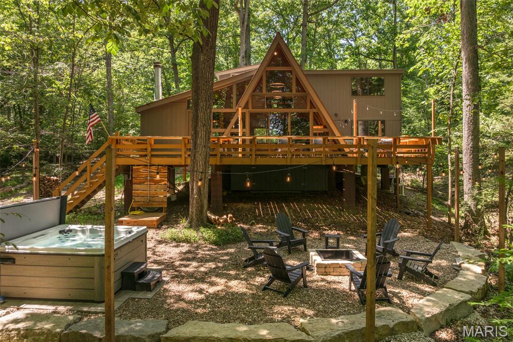 Escape to your own luxury lakefront retreat just 45 minutes west of St. Louis. Whether you're looking for an unforgettable second home to enjoy with family and friends or a high-performing investment property, Highland Hideaway offers a rare opportunity to have both. This beautifully updated Lake Foxfire chalet has earned a reputation as one of Innsbrook's premier vacation rentals, with an exceptional booking history and proven rental income. Offered fully furnished and completely turnkey, it's ready to enjoy the day you close. The open floorplan features a spacious living room anchored by a stunning fireplace, oversized windows overlooking Lake Foxfire, and direct access to an expansive lakeside deck. Designer selected colors accentuate the tongue and groove ceilings and exposed beams. The beautifully remodeled kitchen is designed for entertaining with an oversized island, abundant cabinetry, and generous dining space for family and friends. A half bath is accessible from the living area. The main level primary suite serves as a private retreat. Relax in the spacious bedroom, the bathroom with heated floors, and the sliding glass doors open directly to the deck. Upstairs you'll find two comfortable guest bedrooms, along with a spacious loft offering a second gathering area and office nook. The luxury second full bathroom also has heated floors. Outdoor living is also where this property shines. It creates a natural gathering place where people can enjoy time together while still spreading out. The massive deck provides several areas for dining and entertaining. The hot tub and fire pit are steps away. Enjoy the super charming set up complete with party lights. Check out the adorable bridge that leads to the the private dock and included kayaks. Being sold fully furnished and completely move-in ready, this property includes everything needed to continue operating as a successful vacation rental. The rental business can continue seamlessly, with the buyer working directly with the current rental manager for the smooth transfer of all existing reservations after closing. Important Showing Information: Due to an exceptionally full rental calendar, showings will only be available from the afternoon of July 19 through the afternoon of July 23. To minimize disruption to confirmed guests, any offer must be negotiated and accepted, and all buyer inspections completed during this limited five-day window. Buyers should plan accordingly. This schedule allows the property to continue operating without interruption while providing purchasers the opportunity to complete their due diligence. Whether you're looking for a personal family retreat or an investment property, this chalet delivers an unforgettable lakefront experience.