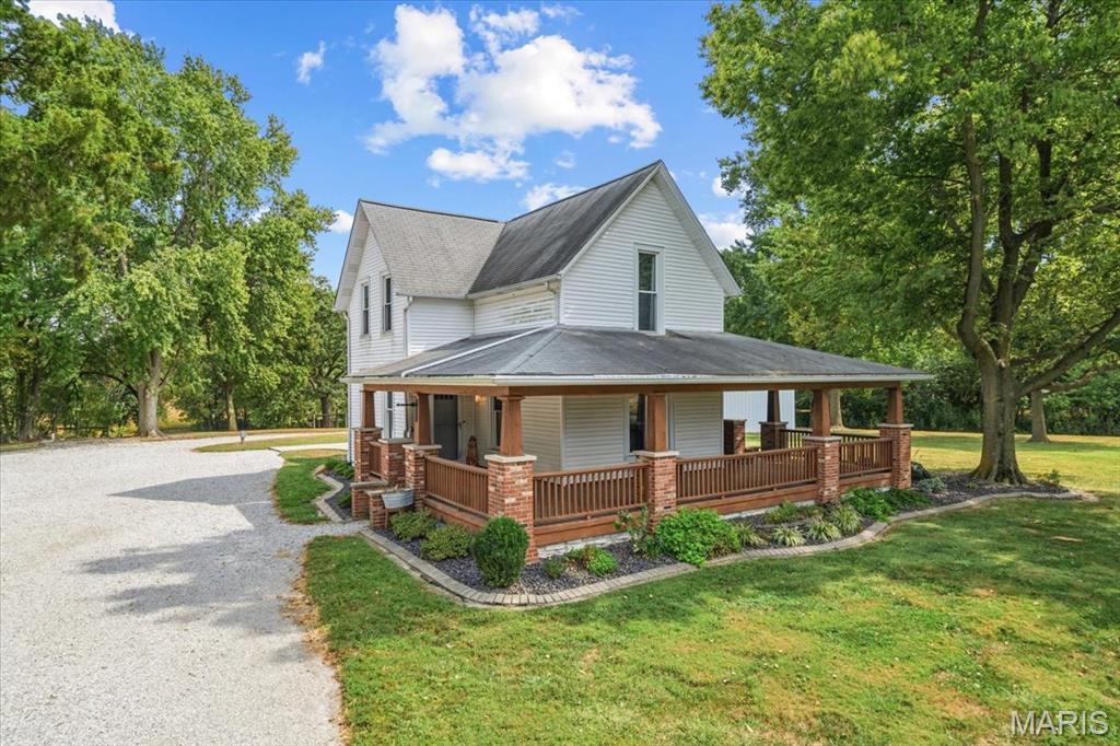 Welcome to your own slice of country living! This beautifully updated 3-bedroom, 2-bathroom home offers approximately 1,755 square feet of comfortable living space, set on a spacious 5.15-acre property with room to enjoy, work, and explore. Inside, you'll find the timeless character of hardwood floors combined with thoughtful updates throughout. The home features a charming wrap-around porch, perfect for relaxing and taking in the peaceful surroundings. Off the back of the home, a large concrete patio provides an ideal space for outdoor entertaining, grilling, or enjoying summer evenings. For those needing plenty of workspace and storage, this property truly delivers. A 20' x 40' lean-to provides additional covered storage, while the impressive 40' x 40' outbuilding offers abundant room for equipment, hobbies, projects, or business needs and includes an insulated office for added versatility. Numerous major improvements have already been completed, providing peace of mind for the next owner, including HVAC system replaced in 2020, Sump pump replaced in 2021, Garage roof replaced in 2021, Garage door replaced in 2022. Whether you're looking for a peaceful country retreat, room for hobbies and projects, or a property with substantial storage and workspace, this acreage offers a rare combination of comfortable living, outdoor space, and functionality. Come see all that this property has to offer! Primary agent phone number 618-444-8921