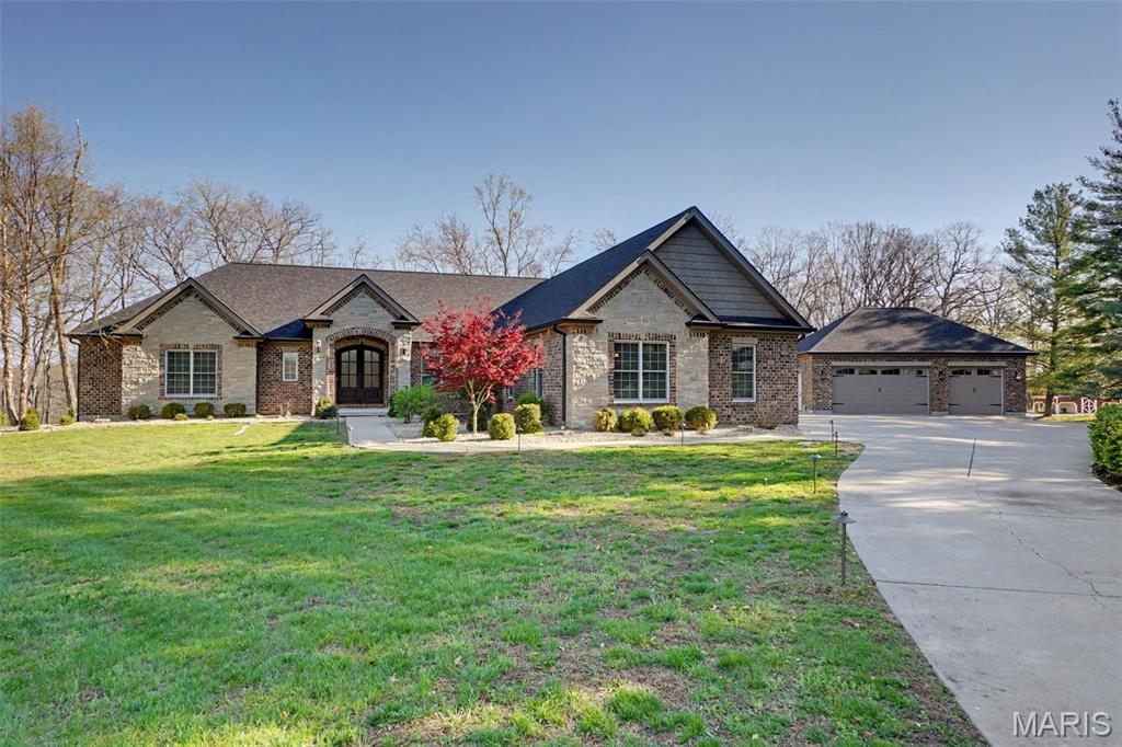 Experience the ultimate in privacy and natural beauty with this stunning custom waterfront property nestled on 37+ mostly wooded acres fronting the serene waters of Callaway Valley Lake. Crafted with exceptional attention to detail, this one-of-a-kind property showcases rich woodwork and impeccable craftsmanship throughout. Highlighted by a grand wood-paneled ceiling with softly arched beams, and a floor to ceiling stone fireplace that lend warmth and architectural elegance to the main living space. At the heart of the home lies an open, elegant luxury kitchen that is sure to impress with custom cabinetry, premium appliances, and generous prep space, making it ideal for both everyday living and entertaining in style. Hop in the side by side and head to the lake to enjoy your own private boat dock, perfect for fishing, kayaking, sunset cruises, or simply soaking in the peaceful lakeside setting. This land is ideal for hunting, hiking, and exploring, offering year-round outdoor adventure in your own backyard. Additional features include a total of 7 garage spaces, a versatile detached 3 car garage, a large chicken coop,  and charming Barn with loft space and concrete floors adding both functionality and character to this exceptional property. All of this is set within a peaceful, wooded landscape that feels worlds away—yet is just minutes from  New Melle, Wentzville and Defiance, Missouri. ATTN: Option to purchase just 32+/- acres with the lake frontage, dock and barn Available!! includes Lake Rights!