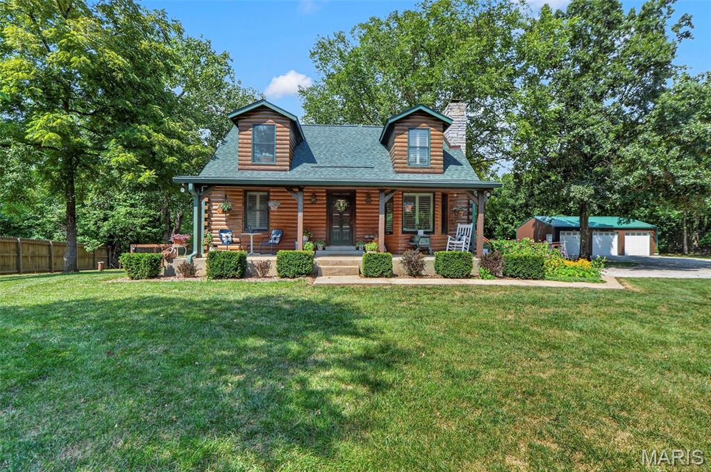 Hidden away at the end of a quiet dead-end road in unincorporated Wentzville, this one-of-a-kind, 3 bedroom, 2 full bath,  log home offers the perfect blend of rustic charm, thoughtful updates, and a lifestyle that's becoming increasingly difficult to find. Situated on 2.762 private acres, this beautifully maintained property has been lovingly cared for and thoughtfully improved over the years.

The charm continues inside with a warm and inviting living room with beamed and wooden ceilings, an updated kitchen, new carpeting, and shiplap ceilings in every bedroom. A brand-new roof adds peace of mind, while the walk-out lower level with a bathroom rough-in provides endless possibilities for future living space.

Outside is where this property truly shines. Designed to live in harmony with nature, the owners have created a peaceful retreat featuring established native flower gardens that bloom throughout the seasons, attracting butterflies, birds, and local wildlife. Enjoy the garden beds, sunflowers, and a custom chicken coop, making it easy to embrace a true homestead lifestyle. Yes... chickens are welcome! Goats too!

The fenced backyard provides plenty of room for pets and play, while the approximate 36' x 24' detached three-car shop offers exceptional space for vehicles, hobbies, storage, or a workshop.

Whether you're relaxing on the covered front porch with your morning coffee, gathering fresh vegetables from the garden, collecting eggs, or unwinding on your scenic, private, back deck enjoying nature, this property offers a lifestyle as much as it offers a home.

If you've been searching for privacy, charm, usable acreage, and a move-in ready log home just minutes from the conveniences of Wentzville, this hidden gem is one you won't want to miss.