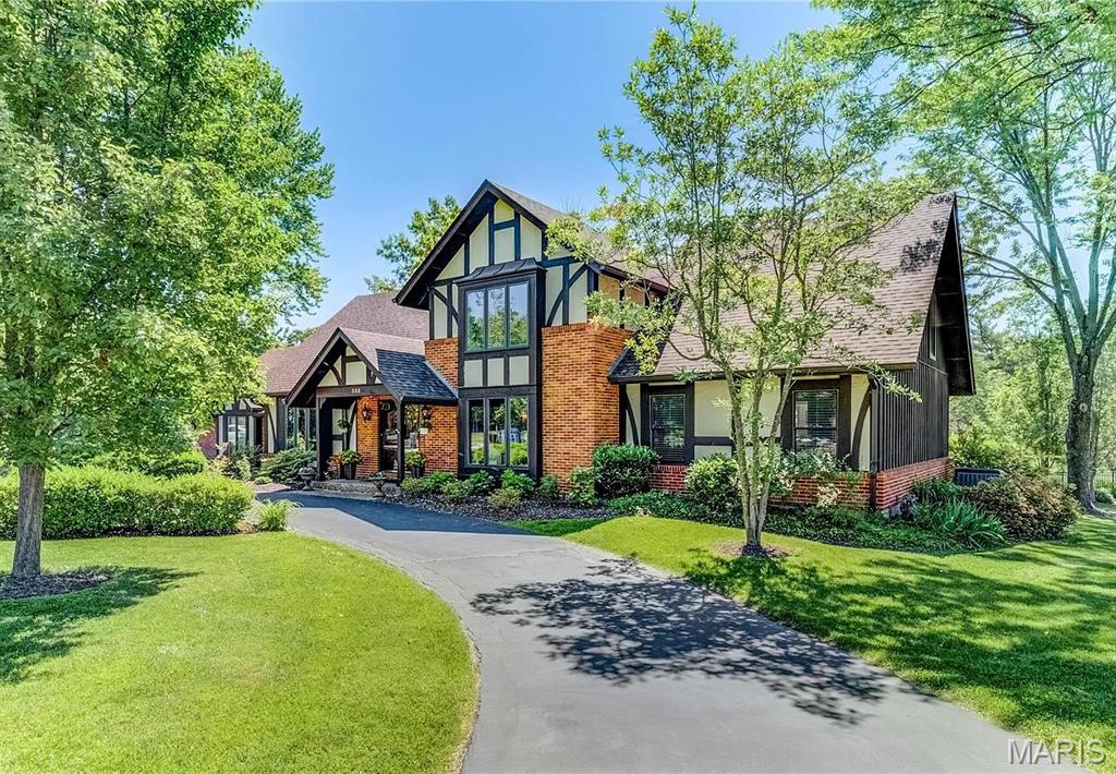 Welcome to 332 Ladue Lake Drive, an elegant Tudor-style residence set on nearly an acre in the prestigious Ladue Lake community. Framed by mature trees and beautifully maintained grounds, this exceptional property offers privacy, timeless character and resort-style living. Enjoy a serene setting with a stocked neighborhood lake and parklike surroundings, all just minutes from Bellerive Country Club, the Elks Club, premier shopping and dining, with convenient access to major highways, the airport and downtown St. Louis.

The spectacular backyard is made for entertaining, featuring a private in-ground pool, expansive decking and new pergola—an inviting retreat for poolside afternoons, alfresco dining and gatherings with family and friends.

Inside, distinctive architectural details create an impressive sense of space. The eat-in kitchen features a center island, rich cherry cabinets, quartz countertops and stainless steel appliances. The show-stopping two-story great room is open to the upper level and showcases soaring ceilings, dramatic floor-to-ceiling wood detailing, a wood-burning fireplace and direct access to the pool and outdoor living areas.

The newly updated main-floor primary suite is a luxurious private retreat, featuring a beautifully renovated, spa-inspired bath with a custom shower/tub combination, updated lighting and an expansive walk-in closet with custom built-ins. Upstairs, three additional bedrooms and two full baths provide generous accommodations for family and guests.

The finished lower level extends the home’s living and entertaining space with distinct family room and game room areas with heated floors—ideal for movie nights, game days or casual gatherings. Additional thoughtful features include heated flooring in the entry, a whole-house generator, main-floor laundry, a circle drive, rear-entry garage and pet fence.

Whether entertaining poolside, gathering in the dramatic great room or simply enjoying the peaceful surroundings, this is a home designed to be enjoyed in every season. An exceptional opportunity to experience the lifestyle and setting that make Ladue Lake so special.