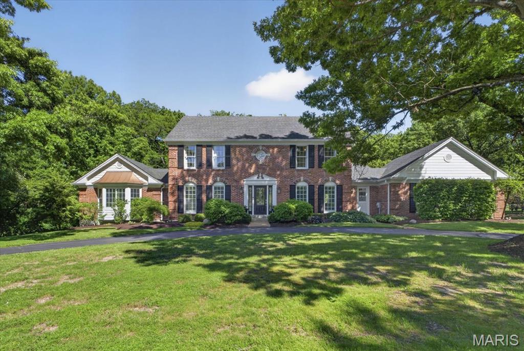 Tucked away on a quiet cul-de-sac in the heart of Town & Country, 1040 Wellington Terrace offers the perfect blend of timeless elegance, functional living, and resort-style outdoor space. Situated on a beautifully landscaped .80-acre lot backing to mature trees, this stately brick home delivers privacy, sophistication, and an ideal setting for both everyday living and entertaining. Inside, you’ll find over 4,500+ square feet of thoughtfully designed living space filled with natural light, soaring ceilings, and rich hardwood flooring throughout the main level. The dramatic two-story great room serves as the centerpiece of the home, featuring expansive windows, a stunning fireplace, and seamless flow into the breakfast room and updated kitchen. Designed with both style and function in mind, the kitchen showcases granite countertops, stainless steel appliances, double ovens, a gas cooktop, oversized center island, and wine cooler. The spacious main-level primary suite offers a private retreat with a spa-inspired bathroom and custom walk-in closet, while three generously sized bedrooms upstairs provide plenty of room for family or guests. The finished walk-out lower level expands the home’s versatility with a large recreation area, additional fireplace, fitness room, office space, sleeping area, and full bath. Step outside to your own private backyard oasis featuring an in-ground pool, expansive patio areas, and peaceful wooded views—perfect for summer gatherings or relaxing evenings at home. Additional highlights include a main-floor laundry room, zoned HVAC, sprinkler system, and oversized 2-car garage. Located within the award-winning Parkway West School District and just minutes from premier shopping, dining, parks, and highway access, this exceptional Town & Country property combines luxury living with everyday convenience.