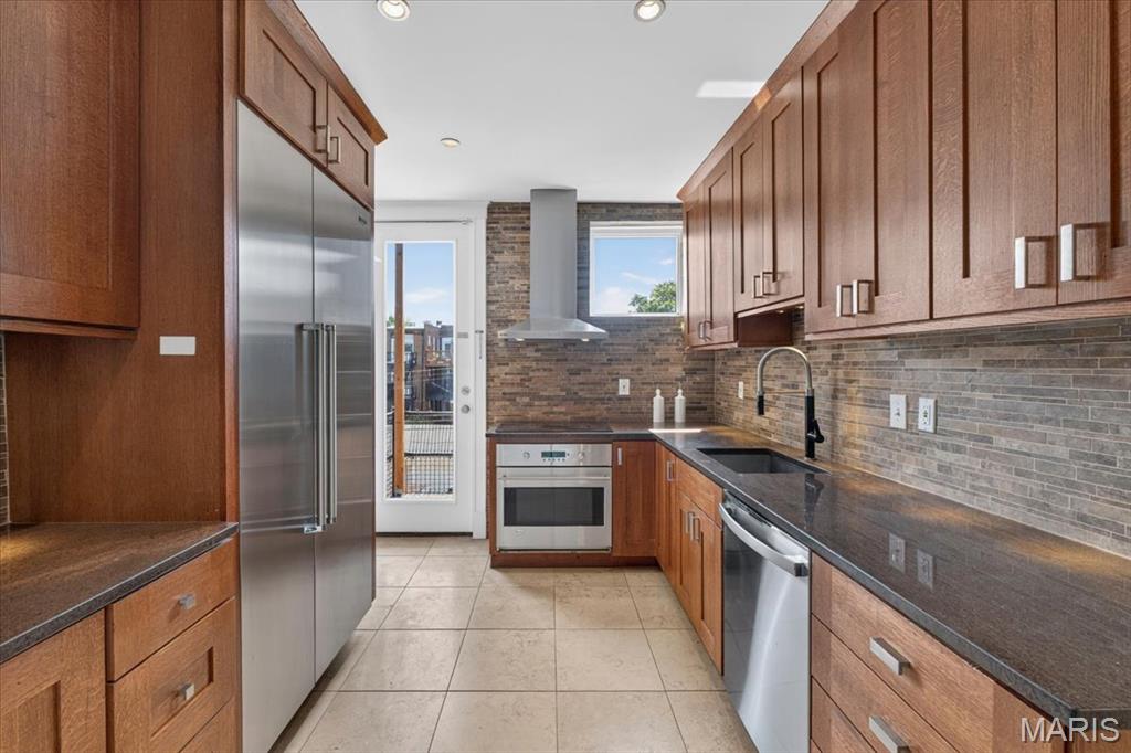 EASY TO TOUR! Picture perfect condo in Clayton.  Perched atop this incredible building is a renovated 1,526 sq. ft. unit, with 3 bedrooms and 2 baths,.  Modern features in the luxury kitchen include a Thermador built-in refrigerator, vented induction oven, granite countertops, under-mount sink, and lovely custom cabinetry. The generous primary bedroom suite features a large walk-in closet and spa-like bath with separate soaking tub and shower and dual vanities. Additionally, the primary has an adjoining room, also accessed via the dining room, perfect for a small gym or home office.  The beautiful living and dining room connect through a charming alcove with built-in shelves evocative of the era of construction. The second bedroom is a large corner room; the third is smaller but accompanied by the second full bath, with a lovely enclosed shower.  Convenient In-unit laundry and a SECOND full-size, large-capacity private set in the basement are also included in the sale. Energy-efficient vinyl windows, new roof, new hardwood floors, bright, sunny and spacious, plus a garage spot and use of the quaint fenced-in yard and garden.  This Demun condo is steps from the famous avenue and directly across from award-winning Captain Elementary and world-famous Forest Park.  See it today.