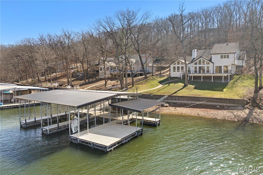 Experience the ultimate dream with this modern oasis at the 11MM of Lake of the Ozarks! This completely renovated 3BR/2.5BA lakefront masterpiece is essentially a brand-new home, blending sleek contemporary design with the natural beauty of a highly desirable Four Seasons. The expansive living area features a gas fireplace and expansive windows that flood the home with light while framing breathtaking views. A chef’s dream, the gourmet kitchen boasts custom cabinetry, stainless steel appliances, and a large center island. The master suite is a true sanctuary, offering a massive walk-in closet with built-ins and a spa-like double shower. Elite Waterfront Living with New 3-well concrete Trico dock (12x28, 12x26, 12x12) with swim platform and dock locker. Super gentle walk-out to 105ft of lake frontage with cove protection. Expansive Trek decking perfect for sunset dining and relaxation. Located in a highly desirable area, this home offers the ultimate lakefront living experience with access to all the amenities that Four Seasons has to offer! This home checks every box for luxury lakefront living with zero compromise.