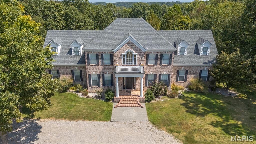 Amazing curb appeal sets the tone for this stunning all-brick estate, perfectly positioned on a picturesque homesite with a sweeping drive. Offering over 6,000 square feet of beautifully updated living space, this 6-bedroom, 5-bath home seamlessly blends timeless design with modern comfort. Inside, soaring cathedral ceilings and abundant natural light create an impressive yet welcoming atmosphere. The spacious living area features a cozy gas fireplace, while the beautifully appointed kitchen showcases new appliances and a custom island that serves as the true heart of the home. Thoughtful upgrades throughout provide both style and peace of mind, including a whole-home water filtration system, new thermostats and updated HVAC motherboards, tinted living room windows, updated lighting and ceiling fans, custom blinds, and a custom-designed master closet system. The expansive full basement, complete with newly added concrete flooring, offers endless potential for additional living, recreation, or storage space. Step outside to your private backyard retreat featuring a newly built deck, pool, and hot tub—perfect for relaxing or entertaining. Extensive dirt work and professional landscaping have transformed the property, including extending the backyard by 15 feet and clearing approximately 50 trees to maximize usable space and open up the grounds. With its combination of size, upgrades, and resort-style amenities, this exceptional home offers luxury living at its finest.
