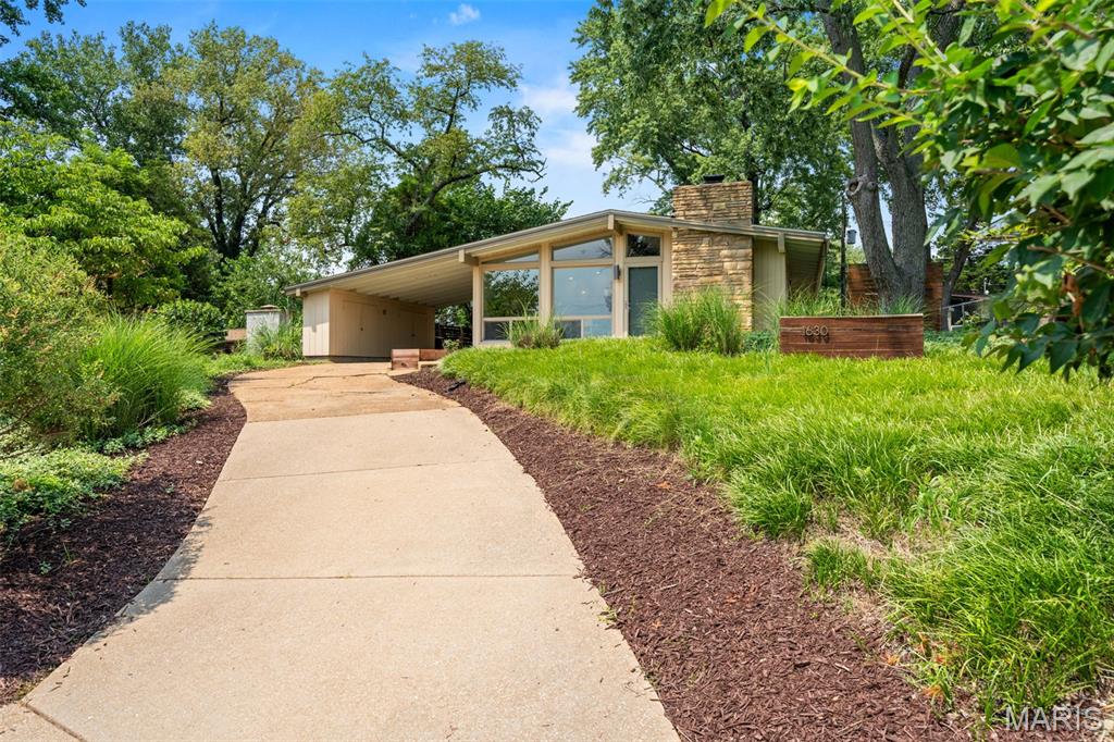 Designed by renowned architect Ralph Fournier, this exceptional mid-century modern home has been thoughtfully restored to honor its original design while incorporating tasteful updates for today's lifestyle. Vaulted ceilings and an open-concept layout create an airy, light-filled living space, where expansive windows frame the lush landscape, a dramatic floor-to-ceiling stone fireplace serves as the focal point, and polished concrete floors complete the home's timeless aesthetic. The renovated kitchen offers the perfect blend of form and function with a large center island, quartz countertops, under-cabinet lighting, abundant cabinetry, and stainless steel appliances. Three bedrooms and an updated full bath provide comfortable living, while a high-efficiency furnace add peace of mind. Outside, discover a private backyard retreat featuring three separate seating areas surrounded by mature trees, perennial gardens, raised planters, solar lighting, and charming rain chains with an engineered drainage system. An oversized carport, additional side storage, and an 8' x 10' storage shed complete this architecturally significant property—a rare opportunity to own a true mid-century modern gem.
