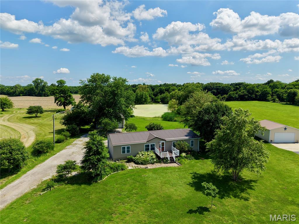 Enjoy peaceful country-style living on 2.92 beautiful acres with wide-open green space, mature trees, and a large scenic pond. This home offers the perfect blend of comfort, privacy, and outdoor enjoyment.

The home features a durable metal roof, attractive exterior curb appeal, and both a front deck and back deck, giving you multiple places to relax, entertain, or take in the quiet surroundings. The property includes a spacious 2-car detached garage, a gravel drive with plenty of parking, and room to spread out.

The land is the true highlight — nearly 3 acres with a large pond, open lawn areas, mature landscaping, garden-style spaces, and a peaceful rural feel while still having nearby access to roads and neighboring homes. Whether you are looking for space for hobbies, outdoor gatherings, storage, gardening, or simply a quiet place to call home, this property offers plenty of possibilities.

A rare opportunity to own acreage, a pond, garage space, and a well-kept home in a beautiful country-like setting.