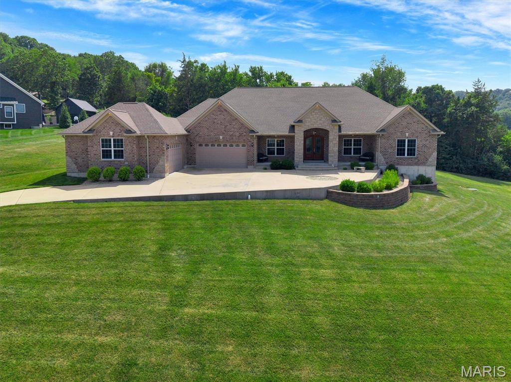 Discover exceptional craftsmanship and luxury living at 2818 Highland Woods Rd. Built in 2016, this stunning all-brick ranch offers timeless elegance, quality finishes, and an ideal layout for both everyday living and entertaining. Step through the impressive double front doors into a grand foyer that opens to rich hardwood flooring, soaring ceilings, and beautifully appointed living spaces filled with natural light. The spacious great room features a striking gas fireplace with a custom wood mantel and vaulted ceilings, creating a warm and inviting gathering space. The chef's kitchen is the heart of the home, showcasing custom cabinetry, granite countertops, stainless steel appliances, a gas range with a custom vent hood, tile backsplash, center island with seating, and a walk-in pantry. Just off the kitchen, the formal dining room with a tray ceiling offers the perfect setting for special occasions. The luxurious primary suite is complete with a tray ceiling, walk-in closet, and a spa-inspired ensuite featuring dual granite vanities, a soaking tub, and a beautifully tiled walk-in shower. There are 3 more generously sized bedrooms. The unfinished walkout basement offers endless possibilities for future expansion, storage, or customization to suit your needs. Step outside to enjoy the covered patio with a ceiling fan, where you can relax, grill, or entertain while overlooking the peaceful, tree-lined backyard that provides privacy and a serene backdrop. An oversized attached four-car garage offers abundant room for vehicles, hobbies, and additional storage. Thoughtfully designed with quality finishes throughout, this exceptional home combines comfort, functionality, and elegant style in one remarkable package.