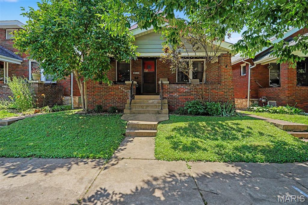 Welcome to 6112 Newport Avenue in the highly sought after Holly Hills neighborhood. This classic South City brick bungalow welcomes you with a charming covered front porch, the perfect place to relax and unwind. Step inside and you'll immediately appreciate the home's timeless character, highlighted by beautiful stained glass windows, original woodwork, and gorgeous hardwood floors that flow seamlessly through the living room, dining room, hallway, and both bedrooms. Original wood doors with glass knobs further enhance the home's historic appeal. While rich in old world charm, this home has been thoughtfully updated where it matters most. The beautifully renovated kitchen features 42 inch cabinetry, a glass tile backsplash, ceramic tile flooring, and abundant cabinet and counter space... and a touch of that original character in the original built-in cabinet that offers extra storage. The updated full bath blends modern convenience with the home's classic style. The full basement provides ample storage and offers an excellent opportunity to expand your living space to suit your needs. Outside, the fully fenced backyard is ideal for relaxing or entertaining, complete with a paver patio and a one car garage with convenient alley access. If you've been searching for classic South City character paired with tasteful updates in one of the area's most desirable neighborhoods, 6112 Newport Avenue is ready to welcome you home.