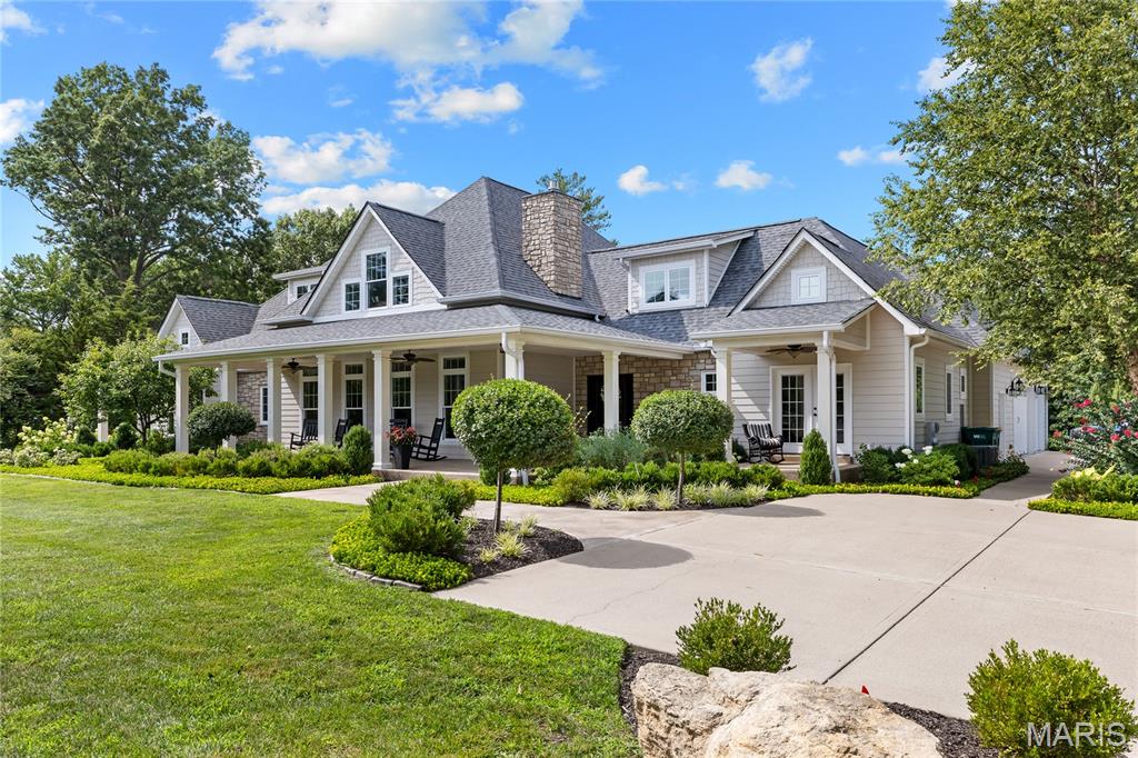 Spectacular stone-crafted 1.5 Sty located on one of Town & Country’s private lanes. This 6348 sq ft Denarvaez-built residence offers thoughtfully designed living space, superior craftsmanship and luxurious comfort throughout.  Entering from the broad covered front porch, the inviting foyer leads to the stunning great room highlighted by a floor-to-ceiling stone fireplace flanked by lighted alcoves with built-in storage cabinets, crescent wet bar and well-detailed dining room. Designed for both everyday living and effortless entertaining, the chef’s kitchen features 42-inch custom cabinetry, granite countertops, stainless steel appliances and a 9’ center island. The coffered primary bedroom suite with marble bath with expanded shower provides an appealing retreat. Two additional ensuite bedrooms complete the main floor living quarters. Oak staircase accesses 4th & 5th ensuite bedrooms and adjoining sitting area. The sensational Lower Level is an entertainer's dream featuring an expansive gathering bar, impressive theater room framed by arched stone entryways, game room, fitness center and full & half baths. Sliding glass doors open to patio with pergola, outdoor living room, pool & fire pit offering the perfect backdrop for entertaining, recreation, and relaxing.