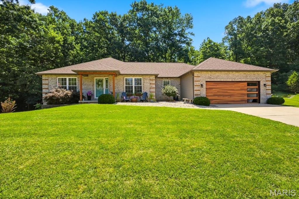Welcome to this beautifully updated 4-bedroom and 3 full bathroom ranch home, located on a cul-de-sac in the Old Mill Estates subdivision, that backs to woods for privacy on a .5-acre lot.  This home provides comfort and privacy.  Updates include:  HVAC (2020), kitchen appliances (2023 - stove/refrigerator/built in microwave/dishwasher), disposal (2021), quartz countertop (2020); finished lower level and added 4th bedroom, water heater (2022), roof (2018), garage door, back patio addition.  Inviting covered front porch with attractive landscaping.  Open floor plan with abundant natural light and gleaming hardwood floors in the main living area.  The formal dining room, with decorative cove ceiling, opens to the spacious vaulted great room with an electric fireplace.  The updated kitchen opens to the adjoining breakfast room that leads out to the partially covered and expanded patio with a gorgeous wooded view.  The open kitchen features updated appliances, quartz countertop, breakfast bar, track lighting and tile floor.  Main floor laundry room adjacent to the kitchen.  Divided bedroom floor plan.  Large main floor primary bedroom suite with ensuite bathroom and walk-in closet.  Two more bedrooms and full hallway bathroom completes the main floor.  Impressive partially finished walk-out lower level with an expansive family/recreation room, wet bar, 4th bedroom, full bathroom, electric fireplace and luxury vinyl plank floor.  Perfect for entertaining.  There are two storage areas in the lower level.  Two-car oversized garage with side door to the yard and additional driveway/parking pad on the left side of the home.  Conveniently located to Hwy 30/Gravois, I-270 restaurants/shops and parks.  Schedule your showing today!