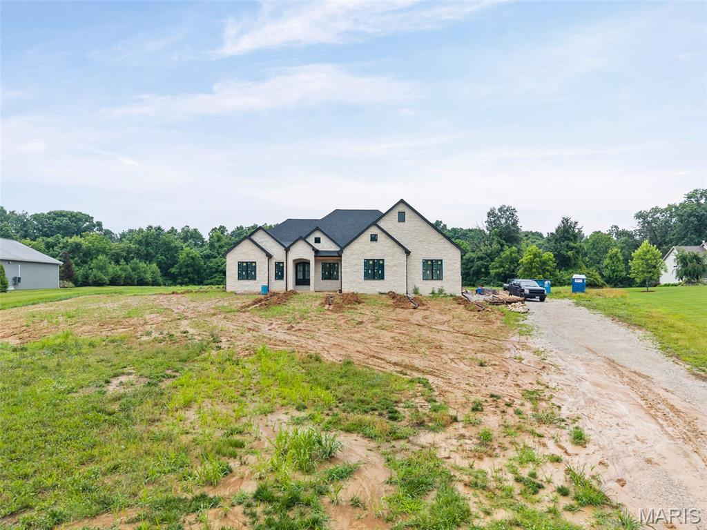 A rare opportunity to secure a generational family estate currently under construction on just over two pristine acres, where enduring craftsmanship, thoughtful design, and timeless elegance are coming together to create a home meant to be cherished for decades. Construction is underway with anticipated completion this Spring, offering the ideal balance of certainty and customization.

This five-bedroom ranch has been intentionally designed for both today and tomorrow, featuring a refined split-bedroom floor plan and an expansive open-concept layout that effortlessly supports everyday living, family gatherings, and milestone celebrations alike. A three-car side-entry garage enhances the home's stately presence while preserving its architectural balance.

At the heart of the home, a chef-inspired kitchen is being crafted to flow seamlessly into the dining and family rooms, creating a welcoming central gathering space. Just beyond, a covered rear porch extends the home's livability and provides a peaceful setting to enjoy the surrounding acreage.

The primary suite is envisioned as a private retreat, showcasing a spa-inspired bath with a luxury wet room, designer finishes, and an impressive walk-in closet. A generous walk-in pantry and thoughtful circulation throughout the home reflect the elevated functionality expected in a truly custom residence.

The opposite wing will feature two spacious bedrooms connected by a beautifully appointed bath, a layout thoughtfully echoed in the finished lower level. Downstairs, the basement expands the home's versatility with substantial storage, a secure safe room, a stylish bar area, and an expansive secondary living space—ideal for entertaining, accommodating guests, or creating multi-generational flexibility.

Perhaps most compelling is the opportunity—while construction remains underway—to collaborate directly with the design team at C&T Homes. Buyers will have the ability to thoughtfully personalize finishes, select details, and make meaningful design choices that align with their lifestyle and long-term vision.

Homes of this caliber, setting, and craftsmanship—combined with the ability to influence the final design—are exceptionally rare. Secure your place, shape the finishing touches, and begin building a legacy designed to endure for generations.