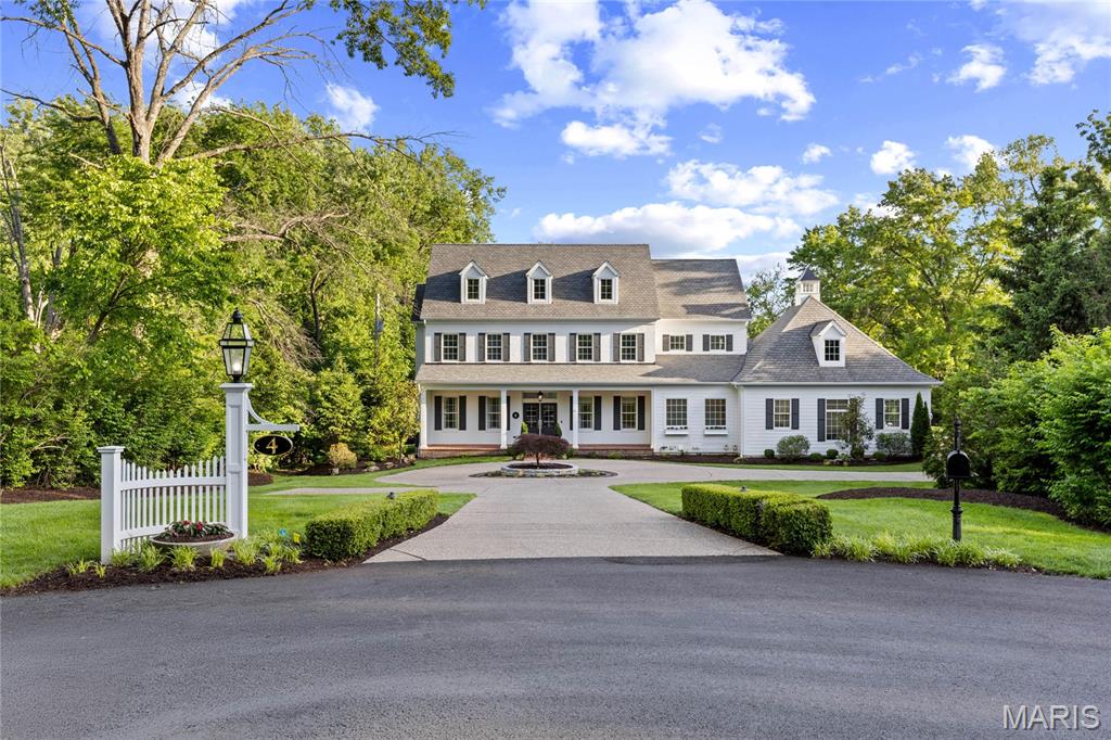 Exceptional craftmanship & distinctive design elements define this spectacular 1.5-sty brick Colonial. Open floor plan features well-proportioned rooms with soaring ceilings, detailed trim work, designer lighting & oak hardwoods that extend throughout the main living area. Wide brick porch entrance with double doors with glass panels leads to expansive hardwood foyer with wine closet, private study with 8’ French doors and elegant dining room with box beam ceiling. Cased arched entryways frame the stunning great room with beamed ceiling, marble fireplace & 3 sets of French doors. Culinary enthusiasts will love the designer kitchen with white cabinetry, quartz countertops, commercial grade appliances & 9’ center island. Vaulted breakfast room adjoins hearth room with cast stone fireplace & sliding glass door to patio. Coffered primary bedroom suite provides an appealing retreat with 15’ customized walk-in closet & luxury bath with freestanding tub. Oak staircase accesses 4 generous-sized additional bedrooms, 3 with ensuite baths, & convenient laundry. Lower Level entertainment space includes recreation room, media room, 6th bedroom & full bath. Sliding glass doors open to outdoor living area with gunite pool, open patio & covered wrap around patio with grilling station & full-height fireplace. Situated on a premium 1+-acre lot at the end of the cul-de-sac with circular drive & 3-car garage.