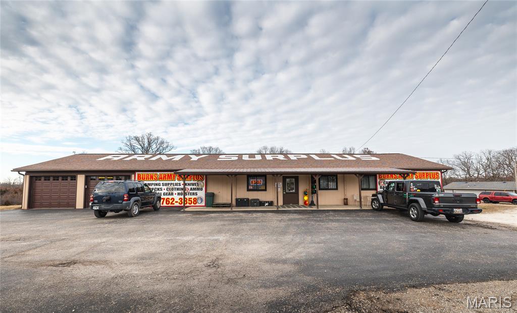 Situated on 7.57 acres m/l, this site is prime to grow your business, or the location for your new expansion. Easy access to I44 off exit 179 on the north/east side of the interstate. Over 1600 foot road frontage and nearby to other businesses. Currently operated as Burns Army Surplus. This property is also generating income with a ground lease for a billboard, plus the car lot renting the corner building of 960 square feet m/l. The main building is over 6400 square feet with warehouse around 1500 square feet.  This site lies outside the city limits with no zoning restrictions. Other features are a paved parking area, 5 overhead doors, additional outbuildings, and pad ready west end portion of the property.  Be sure to see this one to appreciate the traffic, building features, and location!