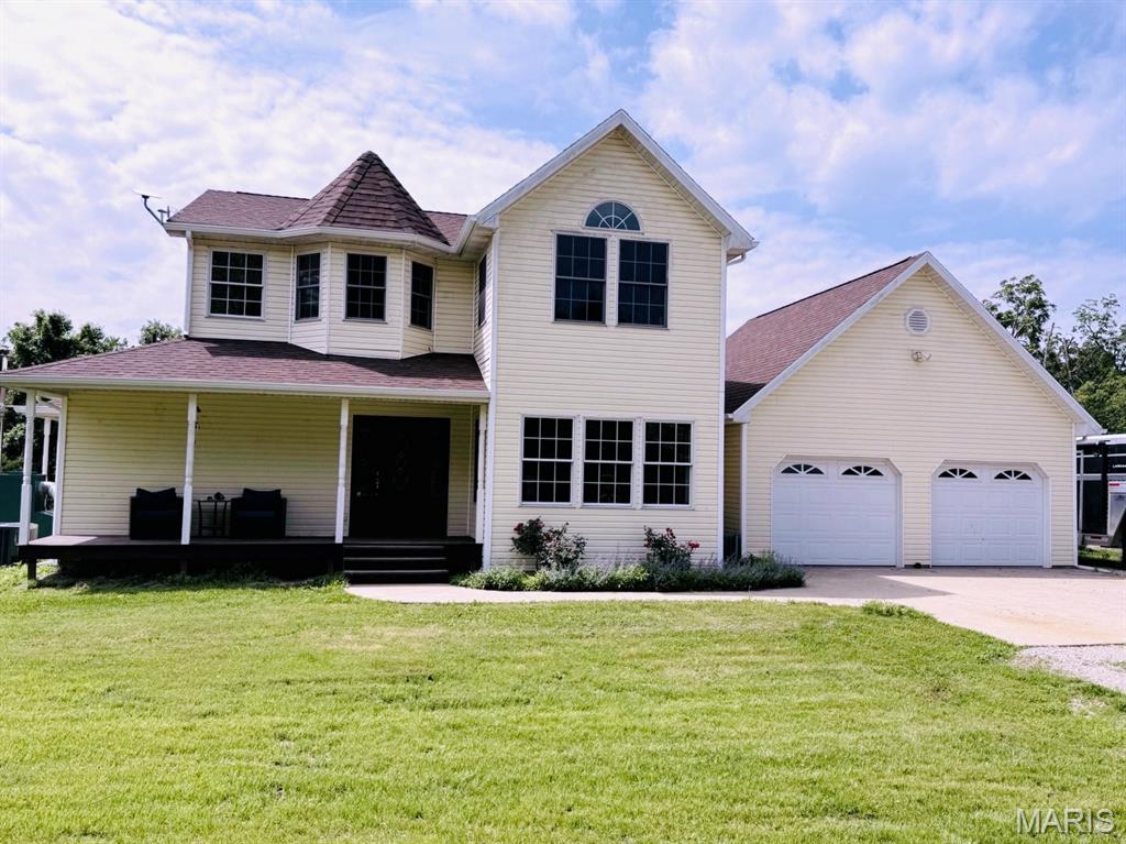 Set beyond the ordinary & immersed in the quiet rhythm of the countryside, this remarkable property invites you to experience a lifestyle where comfort, function, and natural beauty converge in perfect harmony. From the very moment you turn onto the gravel drive, you begin to sense that this is more than just a home-it is an entire way of life. As the drive opens up, a striking 100 x 200 horse arena comes into view, setting the tone for the equestrian possibilities that define this land & welcome riders, trainers & enthusiasts alike into a space designed for both performance & enjoyment. Beyond the arena, the cheerful yellow two-story home stands radiating charm & practicality in equal measure. Its exterior color hints at the light-filled interior waiting inside, where oiled wood floors greet you with a natural warmth that immediately feels like home.The living room, newly carpeted, provides a cozy retreat for quiet evenings, family gatherings, or simply unwinding after a day spent outdoors. 
Overlooking the property, the kitchen allows you to stay connected to the land as you prepare meals, whether you are watching horses graze, monitoring daily farm activities, or simply enjoying the ever-changing scenery. Equipped with a gas cooktop, ample counter space, & a tasteful tile backsplash, the kitchen is designed to accommodate everything from casual breakfasts to elaborate dinners. 
The main floor continues to impress with its thoughtful layout, including a mudroom off of the covered deck that serves as the perfect transition space between the outdoors & indoors. Whether returning from the barn, the fields, or a walk along the property, this area helps keep the home organized & clean.Adjacent to the garage is a separate laundry space, complete with a wash sink. A full bedroom on the main level offers flexibility, ideal for guests, multi-generational living, or even a home office. Nearby, the hall bathroom features a soaking tub that invites relaxation, offering a peaceful retreat at the end of a long day.Upstairs, the primary suite is a true sanctuary, designed to provide a restful escape from the demands of daily life. With its spacious layout, walk-in closet, & beautifully appointed en-suite bathroom, a newly tiled shower & a double bowl vanity, ensuring both style & convenience. A second bedroom upstairs also boasts its own en-suite bathroom with a tub/shower combination. Additionally, the inclusion of a Generac generator offers peace of mind, ensuring that the home remains powered even during unexpected outages.The well system is equipped with an industrial pump capable of servicing the entire property, including strategically placed spigots throughout the farm.
The inclusion of 12 x 20 runs with split panels offers further flexibility, allowing for the separation of horses as needed. Within the barn, a 12 x 13 interior stall is outfitted with built-in feeder & hay storage, ensuring that essential resources are always within reach. A cattle sweep & full working corral provide the necessary infrastructure for handling livestock efficiently. The presence of a workshop adds another layer of utility, offering a dedicated space for repairs and maintenance tasks. The land itself is a defining feature of this offering. Additional cattle ponds and wet-weather creeks enhance the property’s natural appeal. The terrain is thoughtfully balanced, with approximately 60 percent open fields and 40 percent wooded areas, creating a dynamic environment that caters to a variety of uses. The wooded sections are rich with mature walnut and oak trees, providing shade, beauty, and potential value. Bordering Mark Twain land, the property benefits from an added layer of privacy and natural beauty, with protected surroundings that enhance its long-term appeal. In a world where convenience often comes at the expense of character, this property stands as a rare exception, offering both modern amenities and timeless appeal. Roof is 1 year old!