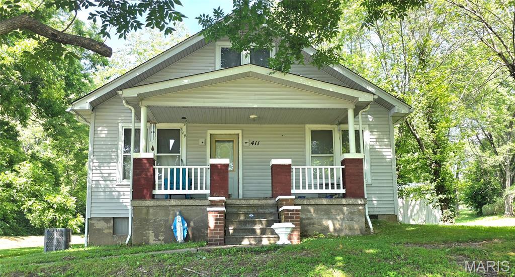 Such an adorable bungalow built in 1935 with a great front porch and back deck sitting on an acre and a half. The big living, country eat-in kitchen, and enclosed back porch give so much room for living! One bedroom and bathroom on the main level, and two more bedrooms upstairs. Full basement with walk-out. The enclosed porch on the back opens up to the 384 sf deck and the huge backyard. The Sauerhage family has lived in this home for many years and loved it. But they need to downsize a bit, mow less and no steps! The historic tile garage with a 300 foot parking in front is 1680 square feet and was a former service station. The station/car repair business closed in 1971 and there may still be some old fuel tanks in the ground there. But it makes for some great storage! Lots of updates and repairs made after the recent storm: new roof in 2023, new vinyl plank flooring and rewiring upstairs 2023, rewiring living room 2023, copper water lines replaced in 2021, furnace and a/c 2015 (high efficiency electric) and water heater 2018. Deck was built in 2015 and new shower in 2018. Come and see this one soon. Sellers are motivated and selling as-is.
