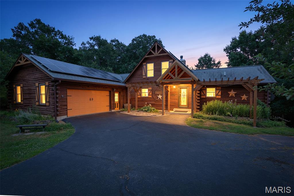Tucked away on 5 scenic acres, this stunning log cabin offers the perfect blend of privacy, rustic charm, and modern comfort. Featuring 3 bedrooms, 2 full baths, and an inviting open floor plan, the home is highlighted by a soaring A-frame great room with dramatic floor-to-ceiling windows, a loft overlook, and a beautiful stone fireplace. The spacious kitchen features a center island, abundant cabinetry, a new refrigerator, a new sink, and flows seamlessly into the main living area, making it ideal for everyday living and entertaining. The primary suite offers a walk-in closet, private bath, and direct access to the oversized back deck. The large screened-in sun porch features new screens and provides the perfect place to relax while enjoying peaceful views of the surrounding acreage. The unfinished walk-out basement includes radiant heated floors and offers endless possibilities for additional living space, a workshop, home gym, or recreation area. Recent updates include a new water heater, a dedicated water heater for the radiant floor heating system, and solar panels for added energy efficiency. Outside, you’ll find raised garden beds, a wet-weather creek, wooded walking trails, a pole barn, and a like-new storage shed, creating an exceptional setting for outdoor enthusiasts, hobby farmers, or anyone seeking room to roam. Conveniently located just minutes from downtown De Soto and a short drive to Festus, this one-of-a-kind property offers the peace of country living without sacrificing convenience.