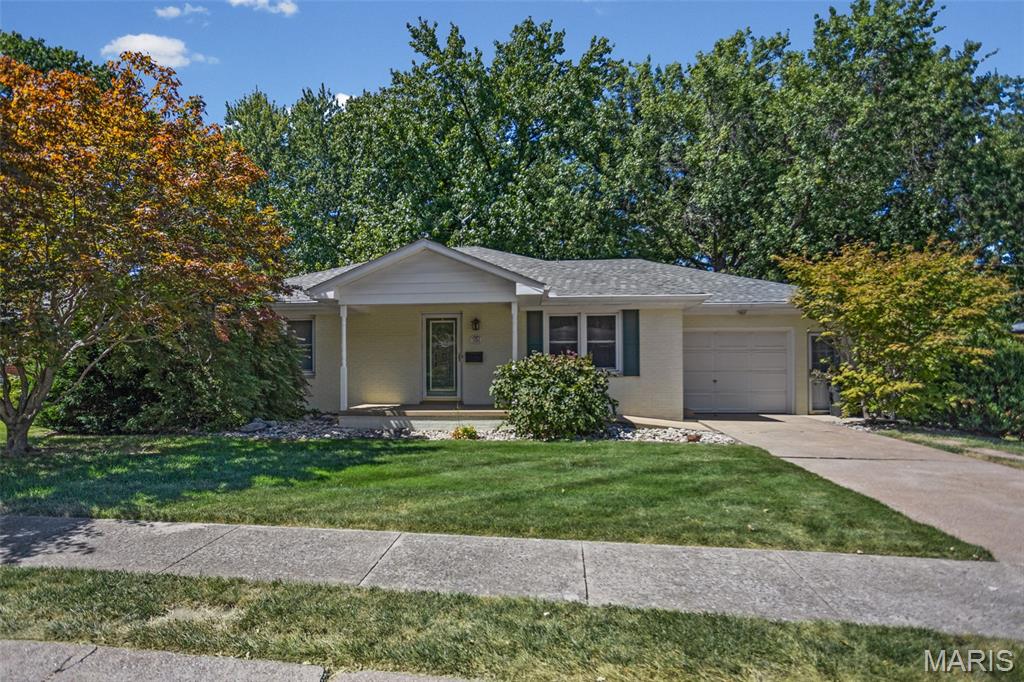 LOCATION, FLEXIBILITY & CHARM! Welcome to this exceptionally well-maintained home in the desirable Montclaire neighborhood within the sought-after Edwardsville school district! Enjoy the convenience of being within walking distance to restaurants, shopping, and everyday amenities. The main level offers a bright, functional layout with a spacious living room plus a versatile bonus space between the rooms—perfect for a home office, reading nook, or flex space. The kitchen features LVT flooring, stainless steel appliances (electric range, refrigerator, dishwasher). Hardwood flooring is tucked beneath the carpet in the larger bedroom, offering an opportunity to showcase the home’s original character. A second bedroom features beautiful wood flooring and provides access to a charming 5’ x 15’ glass-enclosed sun porch, perfect for morning coffee or relaxing year-round. The lower level is full of possibilities!  Featuring a spacious 15’ x 32’ family room with a separate entrance and walk-out access, plus a bonus room previously used as a bedroom, this level offers tremendous flexibility. A second kitchen includes an electric range, refrigerator, washer, and dryer, along with additional space ideal for a dining area. A convenient ¾ bath with a tiled shower completes the lower level. This versatile space could be perfect for extended family, a college student, guest accommodations, recreation, or simply additional living space—the possibilities are endless! Recent updates include a new roof within the past two years, 2020 gas furnace, and 2018 water heater. Additional storage can be found in the partially floored attic and the 10’ x 14’ shed. Enjoy the peaceful, well-shaded backyard and the convenience of walk-out access from the lower level. A wonderful combination of location, condition, flexible living space, storage, and opportunity—this one is ready to welcome its next owner!