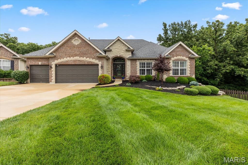 Welcome to this spectacular 4-bedroom, 3-bathroom atrium ranch in Wentzville, boasting premium upgrades inside and out. The open-concept main level features 9-foot ceilings, gleaming hardwood floors, and a vaulted living room anchored by a cozy gas fireplace. A gourmet kitchen stands ready with 42-inch cabinets, granite countertops, updated appliances, a double-oven stove, a built-in beverage cooler, and touch-control faucet. The desirable split-bedroom floor plan ensures privacy, highlighting a primary suite with a coffered ceiling, walk-in closet, dual vanities, a soaking tub, and a separate shower. The main level also provides dedicated laundry space. Downstairs, an incredible, updated walk-out basement awaits, complete with waterproof luxury vinyl plank flooring, an electric fireplace, a private bedroom, and a full bathroom. An entertainer's dream, this lower level features a large wet bar that comes equipped with its own dedicated dishwasher and refrigerator. Step through a custom Murphy door to reveal a hidden, soundproof home theater room, or head into the private home gym space with direct patio access. Peace of mind is guaranteed by major system updates, including a roof, siding, and gutters replaced 2.5 years ago, alongside a newer furnace, HVAC system, and water heater. Your private outdoor oasis features a maintenance-free deck leading down to a massive patio illuminated by integrated LED lighting. The fully fenced yard with mature trees hosts a premium, heated, salt-water inground pool with a stone waterfall, alongside a private fire pit and a premium hot tub included in the sale.