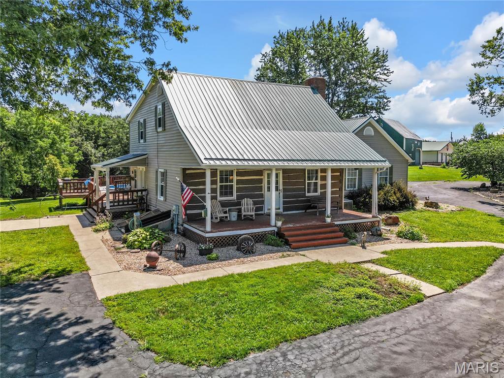 Step back in time without sacrificing modern comfort on this exceptional 15-acre property just 10 minutes from Hermann, Missouri. Rich in history and character, this beautifully preserved 4-bedroom, 2-bath historic log home showcases stunning original craftsmanship, spacious bedrooms, and timeless charm throughout. The clean stone and block basement/cellar offers excellent storage. Outside, you'll find a property designed for both relaxation and entertaining. Unwind on the large covered front or side porch, cool off in the above-ground pool surrounded by a spacious deck, or gather with family and friends under the covered pavilion featuring a built-in firepit an ideal setting that has hosted countless celebrations and special occasions over the years.

The historic barn, constructed with a log frame and protected by metal siding, provides excellent storage for equipment or could easily accommodate livestock. Car enthusiasts, hobbyists, or business owners will appreciate the impressive insulated, temperature-controlled shop with metal interior and exterior, complete with a bathroom, kitchen area (appliances not included), and laundry hookups.

The land offers a beautiful mix of mostly open pasture with scattered woods, creating endless opportunities for horses, livestock, recreation, or simply enjoying the peaceful countryside. Historic log homes of this caliber rarely become available. Whether you're searching for a full-time residence, weekend getaway, or a place where generations can gather and make memories, this one-of-a-kind property is truly something special.