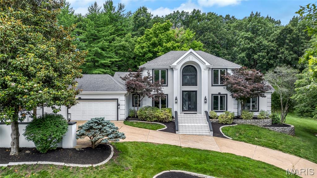 Welcome to 1909 Shepard Road. This beautifully updated 4 bedroom, 3.5 bath residence offers approximately 6,000 square feet of finished living to enjoy, nestled on a .93 acre lot in the heart of Wildwood. Offering exceptional living and entertaining spaces, this home combines timeless architecture with extensive updates and a rare detached carriage house/separate residence, adding an additional 1 bedroom and 1 full bath. A dramatic double front entry door welcomes you into the two-story foyer and opens to elegant formal living spaces, featuring designer architectural details and rich hardwood flooring throughout. The soaring great room showcases a stunning two-story stacked stone fireplace, anchored by generous windows. The renovated kitchen is designed for both everyday living and entertaining, featuring custom cabinetry, quartz counters and backsplash, center island, breakfast bar, walk-in pantry, Sub-Zero refrigerator and adjoining light-filled breakfast room. The hearth room offers a gas fireplace, custom built-ins and access to the sunroom and deck. A main floor laundry room and half bath adds convenience. The main floor primary suite serves as a private retreat with vaulted ceiling, sitting area, dual closets and direct deck access. The luxurious ensuite bath features dual vessel sinks, soaking tub and walk-in shower. Upstairs, find two additional ample guest bedrooms, serviced by a full bath, as well as a versatile loft area. The finished walk-out lower level expands your living space with a recreation room, wet bar, wine room, family room with fireplace, additional bedroom, full bath and abundant storage. Car enthusiasts, hobbyists and entrepreneurs alike will appreciate the 6 garage spaces - including an oversized, attached 3 car garage as part of the main residence and a 3 car attached garage to the carriage house. The carriage house/separate residence offers a private entrance, spacious family room, kitchenette, bedroom and full bath - creating endless possibilities for guests, multigenerational living, home based business, telecommuting purposes and more! Extensive updates list includes fresh interior paint, newer HVAC systems and more. Nestled in nature, backing to common ground, surrounded by mature trees and lush landscaping, this exceptional property offers privacy, flexibility and a sought-after locale.