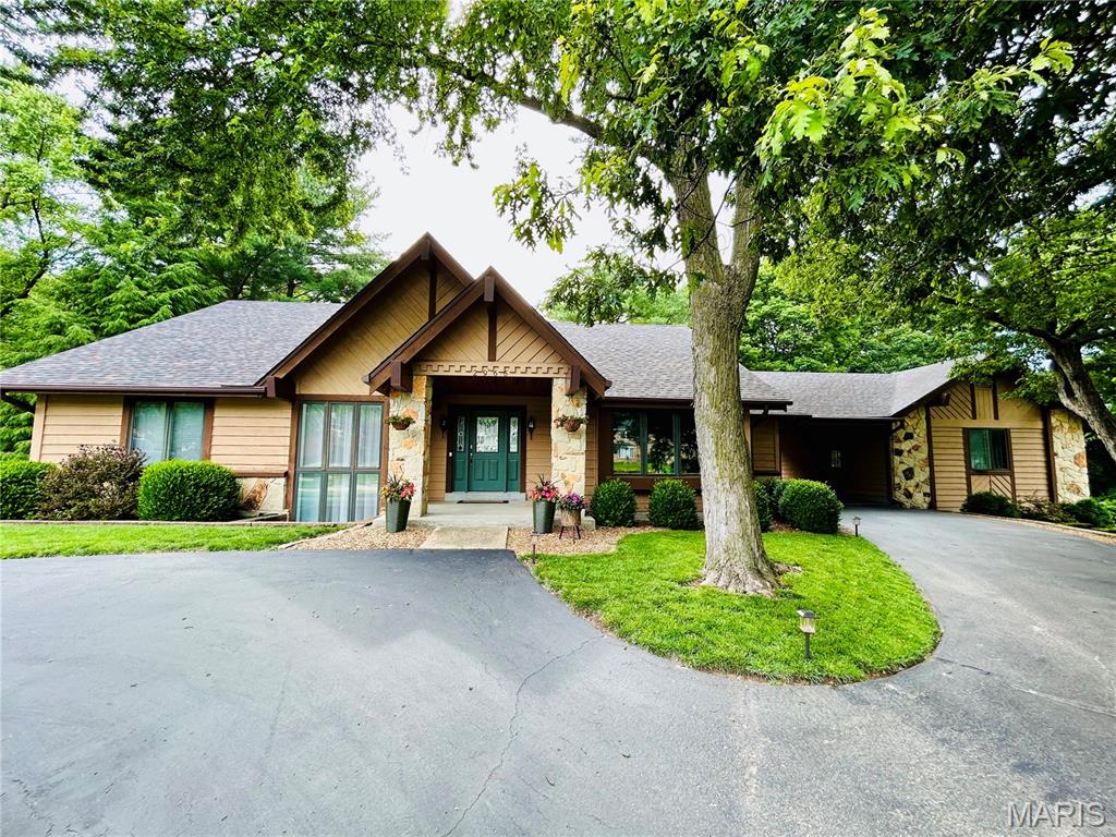 HERE IT IS! This highly sought-after, custom-built masterpiece is finally hitting the market! Nestled perfectly at the end of a prestigious cul-de-sac, this gorgeous resort-style yard with its beautiful, mature trees situated on 1.24 acres has captured the interest of many! The elegant circle driveway welcomes you, offering abundant parking for guests. The exterior design seamlessly connects a spacious two-car garage with a versatile breezeway which doubles as an additional covered carport. As you enter you are greeted by a magnificent character created great room with vaulted ceilings for an airy ambiance. In addition to that, the rich luxury vinyl flooring and solid wood doors soar throughout the home giving created charm. A custom stone fireplace serves as a dramatic focal point of the room. Adjacent to that, the lovely 3-seasons room is sure to please as a quiet retreat for reading, having coffee, or enjoying your outside oasis. With 5 bedrooms and 3 1/2 freshly updated baths, this home is sure to impress! The beautifully designed main floor master bedroom features a spa-like en-suite bath and an expansive custom walk-in closet. Your guests will feel at home in the large dining room that boasts warm lighting and rich textures. The stunning chef inspired kitchen boasts updated lighting, quartz countertops, spacious pantry, stainless-steel appliances, and convenient walk out to the newer premium engineered no maintenance deck. Situated by the kitchen is your main floor laundry and mud room. Enjoy effortless indoor-outdoor living with a finished lower level that walks out directly to a sprawling patio and a separate flat backyard wrapped in timeless wrought iron fencing. This fully secured lower oasis flows out into the massive 1.24-acre lot, anchoring an incredible, designated bonfire area built for unforgettable nights. The fully finished lower level includes 3 bedrooms, full bath, a custom bar, and a premier wood burning stove. In addition to that, there is plenty of storage with a double walk out in lower level and basement area. 
                                    NEWER ROOF (2020), NEWER HVAC (2019), NEWER WATER HEATER (2019)