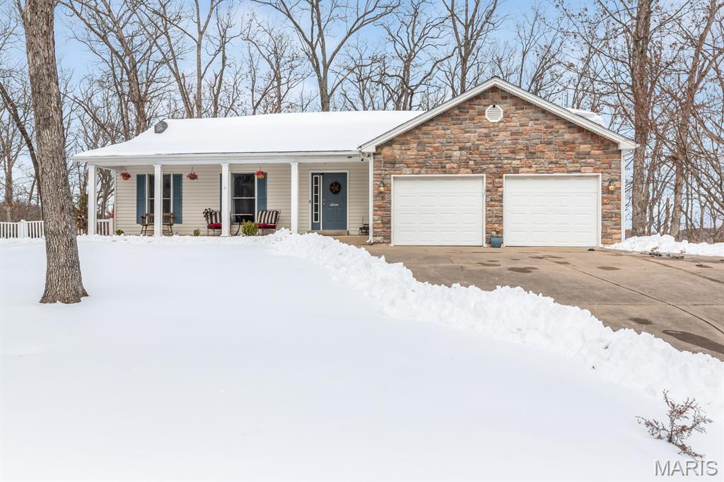 Well-maintained home with excellent curb appeal, featuring a covered front porch, stone accents, and an attached two-car garage. Inside, the open-concept layout offers vaulted ceilings, new LVP flooring, and a cozy stone fireplace anchoring the main living space. A wall of windows fills the home with natural light and highlights peaceful wooded views. The kitchen features solid wood cabinetry, ample counter space, stainless steel appliances, and a functional layout that flows seamlessly into the living and dining areas—perfect for everyday living and entertaining. Step out back to a composite deck with stairs leading down to the back patio, providing great outdoor space for relaxing or hosting. Set back from the road on an oversized 0.61-acre lot, this home offers exceptional privacy compared to others in the community. The backyard overlooks a serene hillside valley—lush and tree-filled in summer, with expansive nature views in winter. The walkout basement provides an additional 1,500 square feet of unfinished space, ready to be customized to suit your needs. As a Lake Sherwood owner, enjoy access to outstanding amenities including six lakes, a clubhouse and Lakeside Grill, new community pool, sandy beach, marina, fishing docks, campground, 24-hour gated access and staffed security. Conveniently located in Marthasville—close to Augusta, Foristell, and New Melle in the heart of Missouri wine country—and just 15 minutes from Washington and Wentzville. Please note this is a gated community, and showings require a Realtor present. Come experience lake life in Lake Sherwood MO!