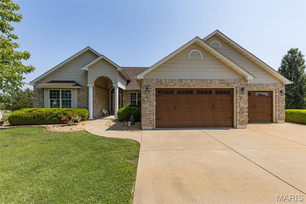 Beautifully designed and tucked away on a quiet cul-de-sac, this brick front home offers spacious living, quality finishes, and a private backyard setting. Inside, wood floors flow through the main living areas, leading to a spacious living room with vaulted ceilings, a gas fireplace, and built-in bookshelves. The large kitchen is made for gathering, featuring granite countertops, an oversized island, abundant cabinetry, and an adjoining dining area. The main-level primary suite offers a walk-in closet and private bath with a jetted tub and separate shower. An office, half bath, and convenient main-level laundry complete this floor. The finished lower level provides plenty of additional living space with two bedrooms, a full bath, family room, and wet bar with mini refrigerator—perfect for entertaining or relaxing. Two storage areas offer plenty of room to keep everything organized. Step outside to the covered, screened-in patio and enjoy the privacy of the backyard. A three-car garage provides excellent space for vehicles, hobbies, and storage. With generous living and entertaining spaces inside and out, this home offers comfort, functionality, and a great cul-de-sac location.